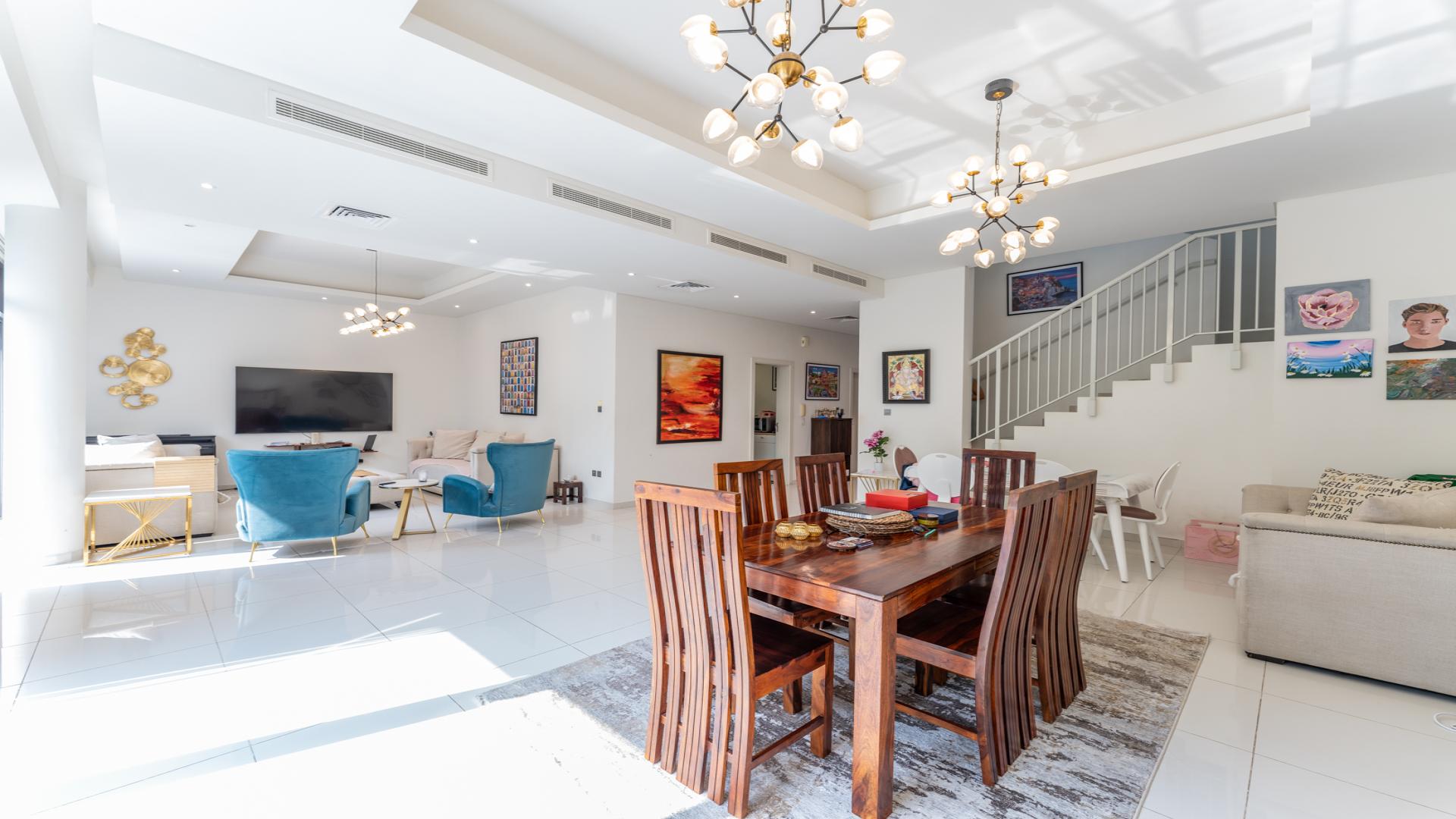 Exterior view of modern 5-bedroom villa in Damac Hills, surrounded by lush greenery