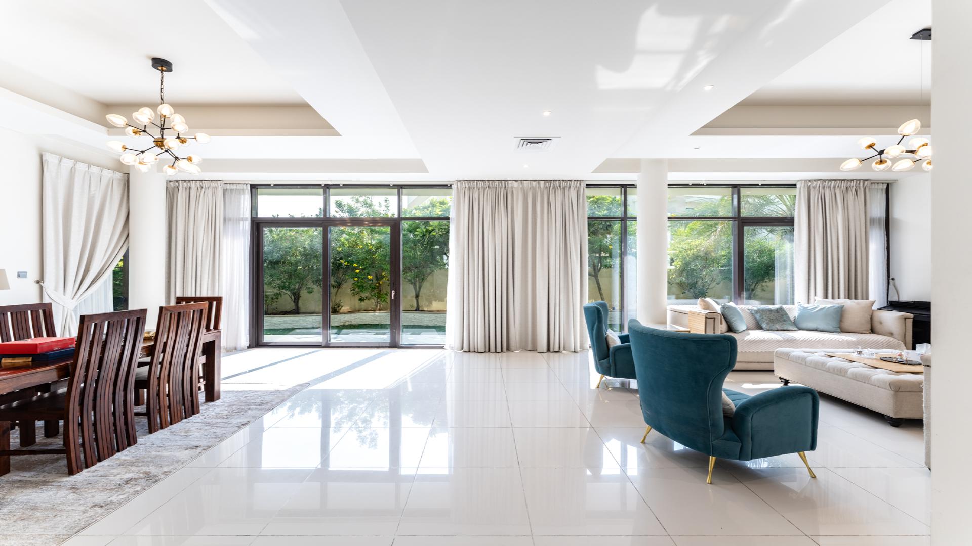 Spacious living and dining area in Damac Hills villa, modern decor, bright ambiance