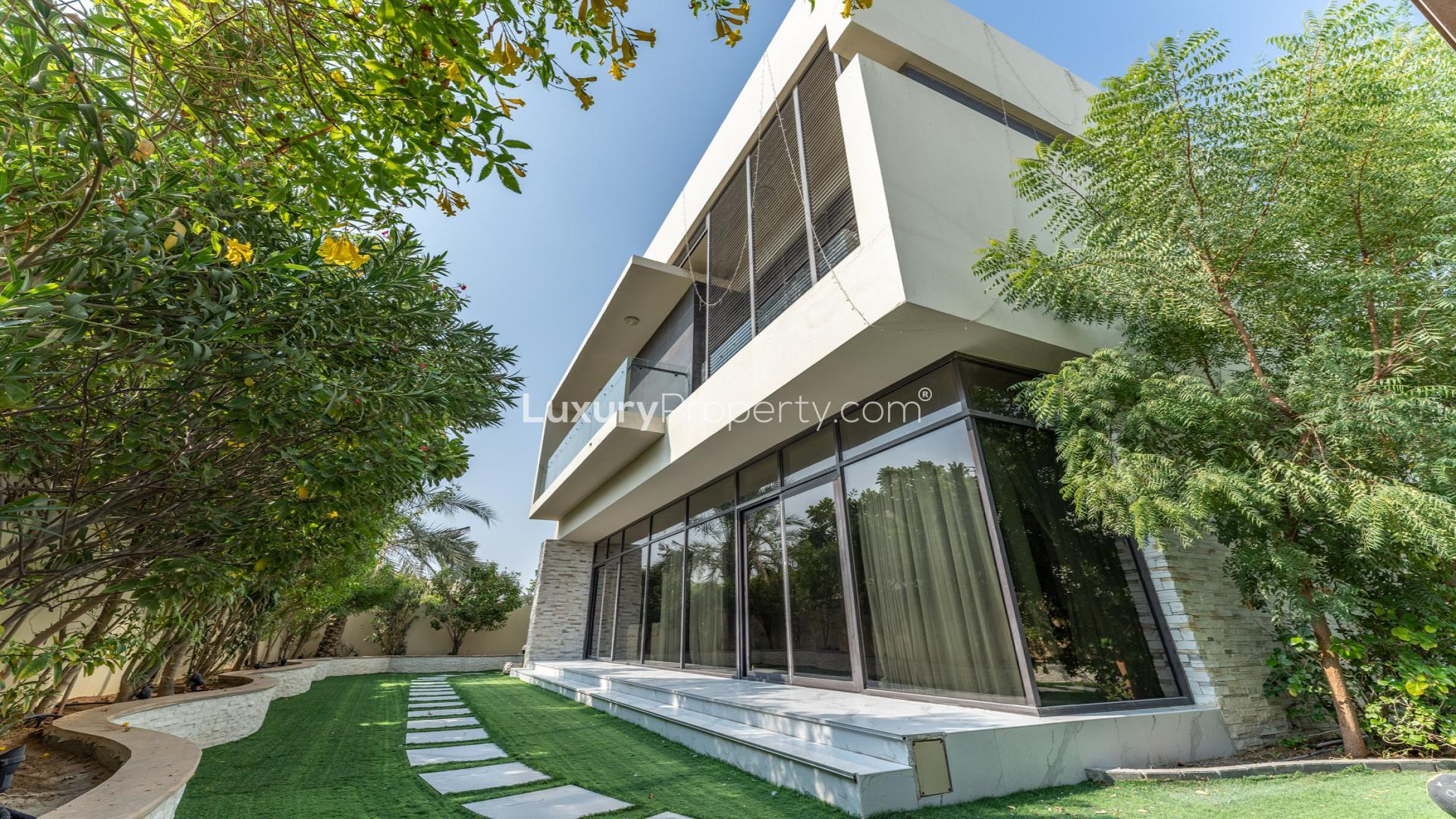 Spacious living room in 5-bedroom villa, Damac Hills, featuring modern decor and large windows