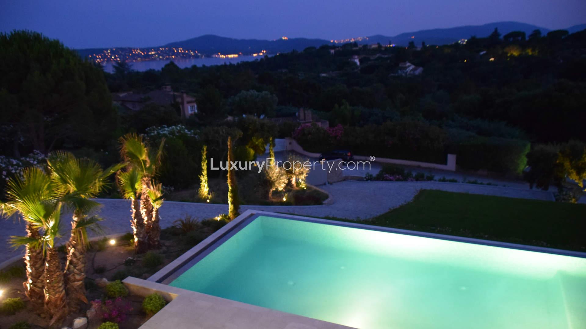 Luxurious Saint Tropez villa terrace with pool overlooking Gulf of St Tropez at dusk