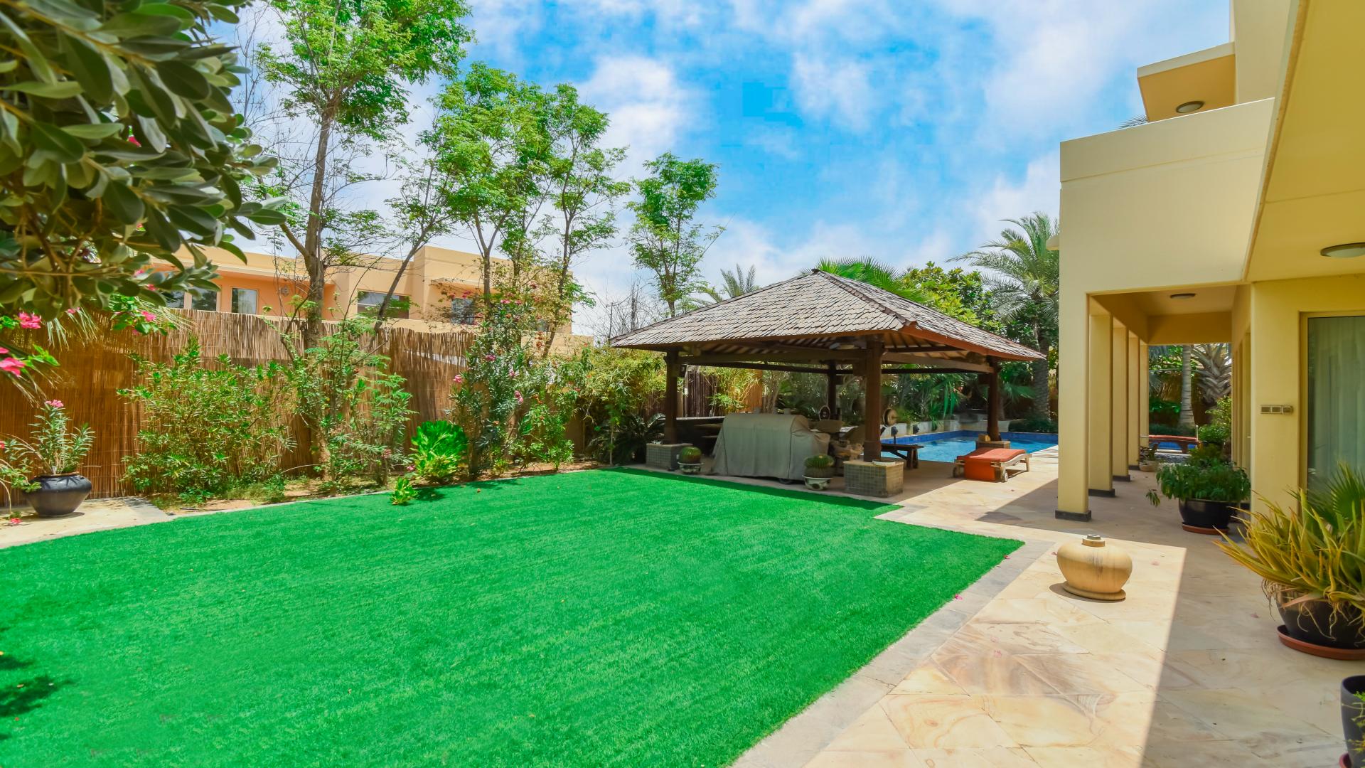 Luxurious villa poolside view in Savannah, Arabian Ranches, surrounded by lush greenery