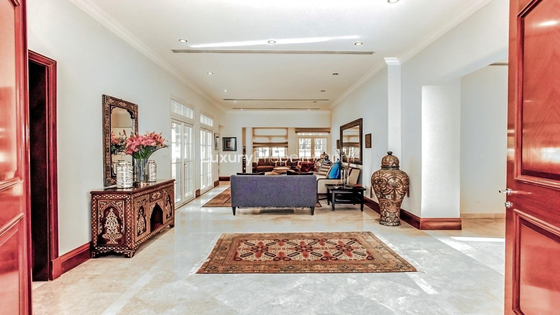 Luxurious Emirates Hills villa entrance with elegant architecture and lush landscaping, Sector E