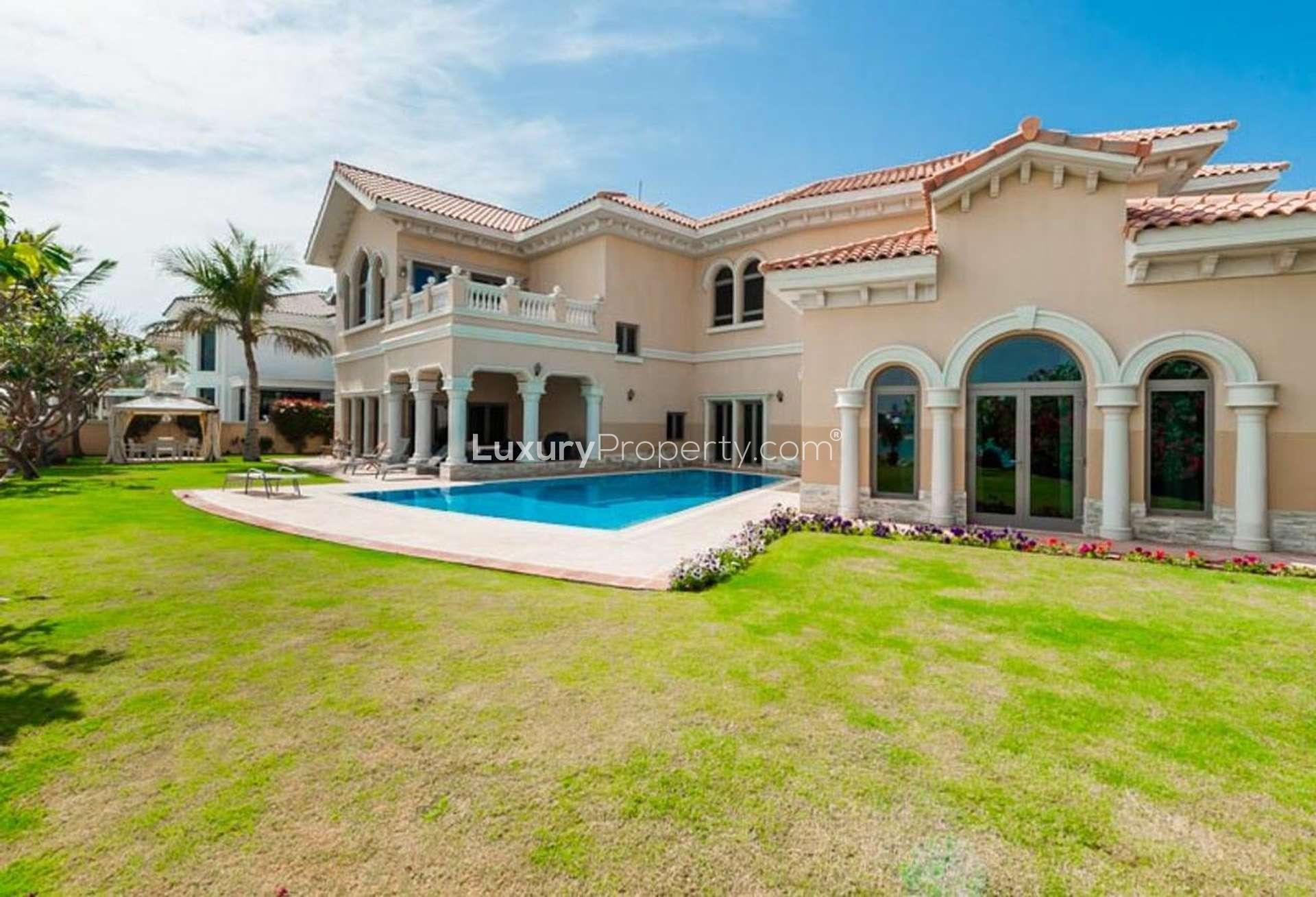 Dining room with wooden table in luxury Emirates Hills villa, large windows, elegant decor