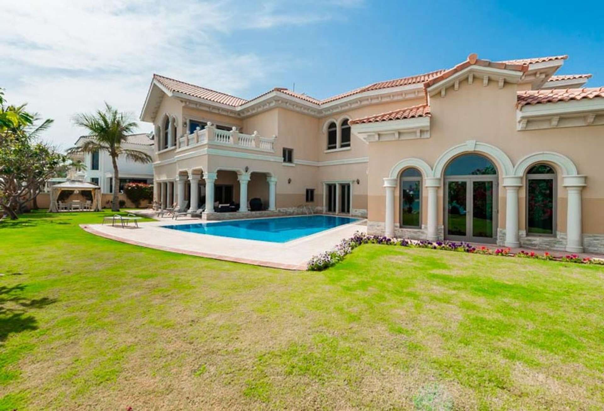 Dining room with wooden table in luxury Emirates Hills villa, large windows, elegant decor