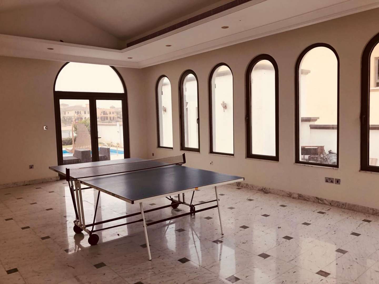 Table tennis room in beachfront villa, Palm Jumeirah, with large windows and marble floors