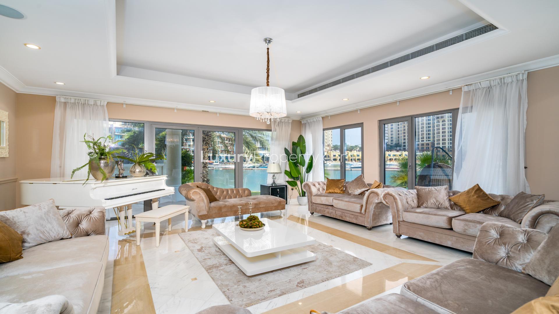 "Stunning 5-bedroom villa for sale in Palm Jumeirah, featuring lush landscaping and elegant design.",Luxurious living room in upgraded Signature Villa, Palm Jumeirah, featuring elegant furnishings and views