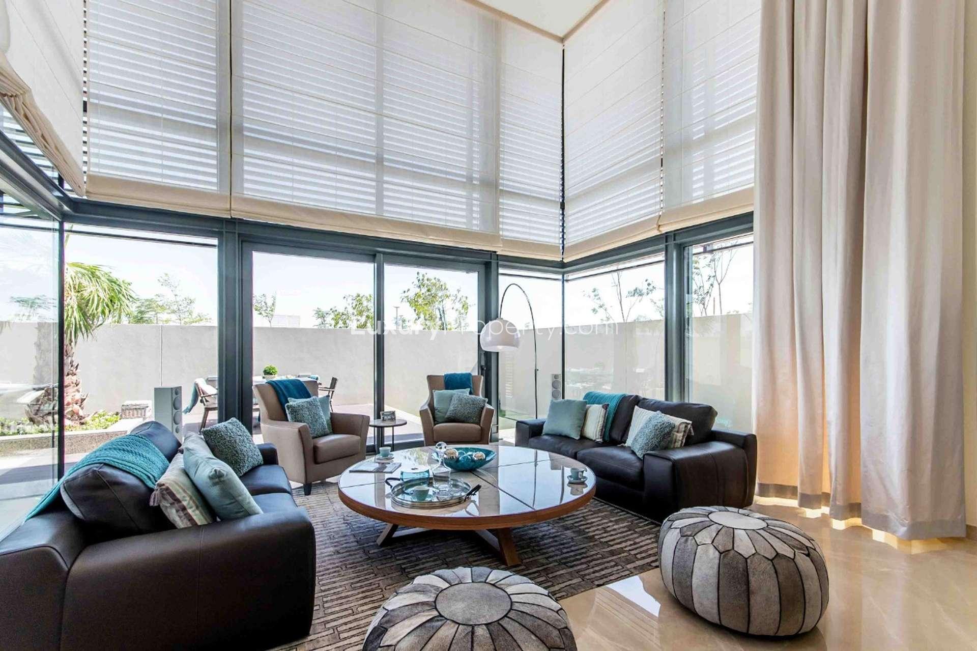 Luxurious living room in Sobha Hartland villa with modern furnishings and large windows