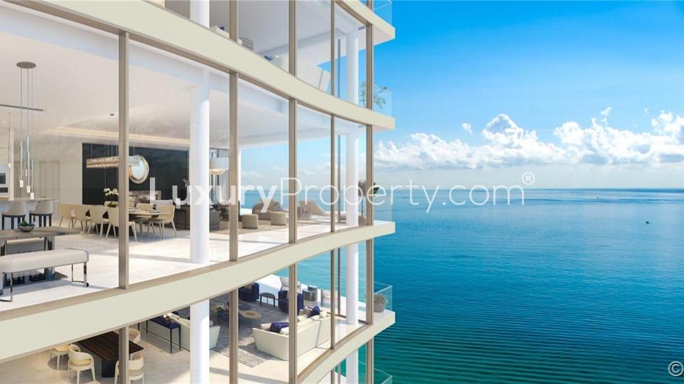 Oceanfront villa balcony with dining table, stunning sunset view over Sunny Isles Beach