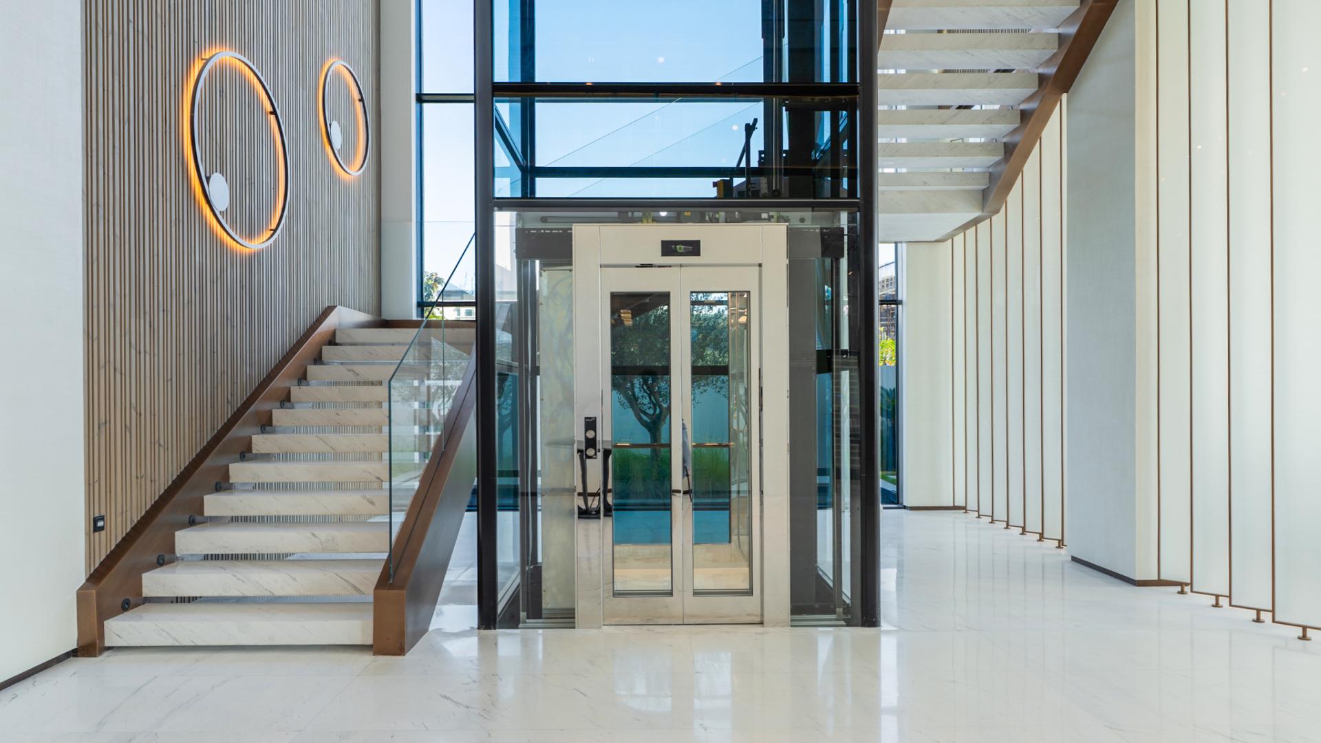 Luxurious open-plan living area in La Mer villa, Jumeirah, with modern furnishings and garden view