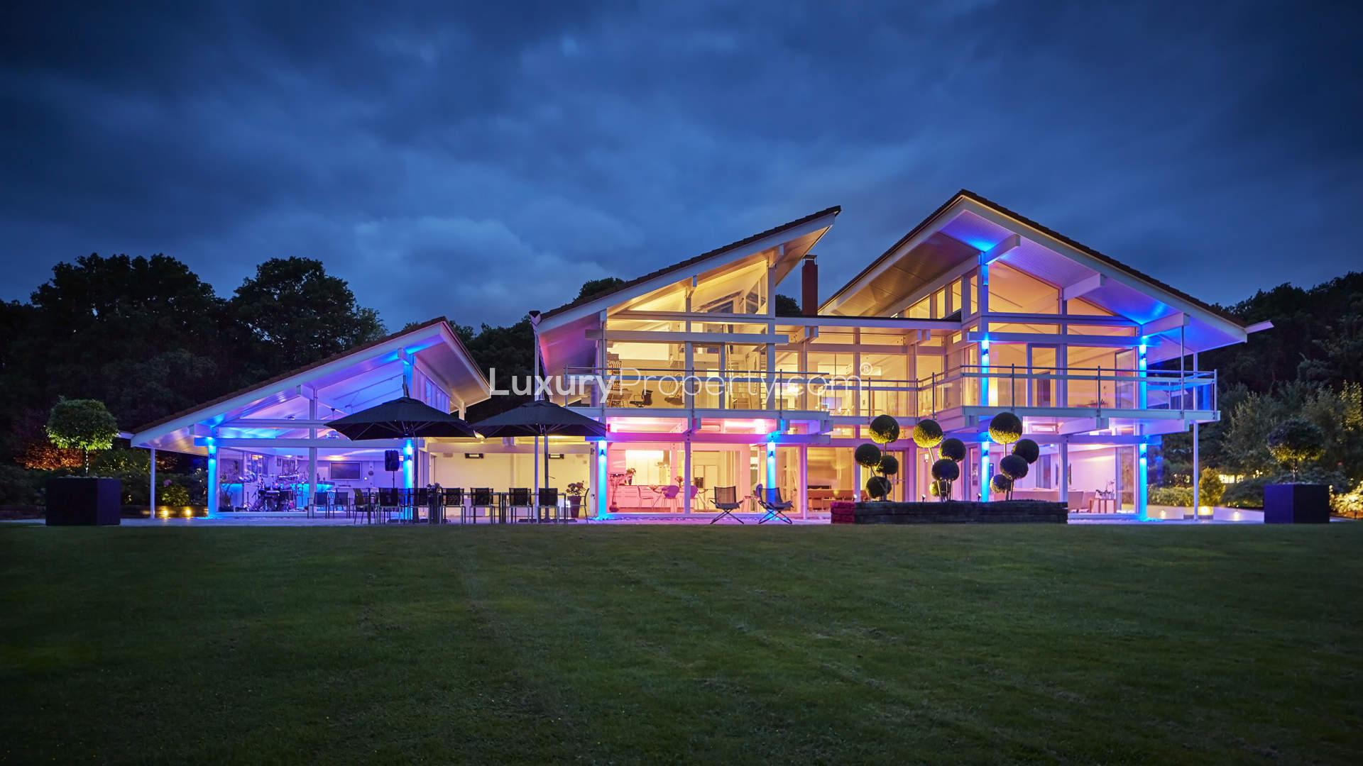 Aerial view of luxurious lake house villa with tennis court in Sussex, near London