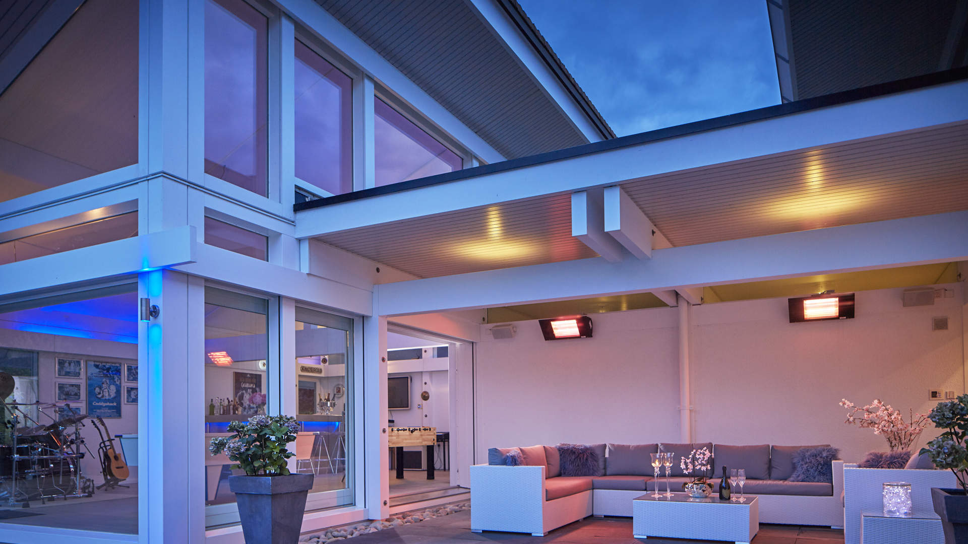 Luxurious contemporary villa exterior with vibrant lighting, spacious lawn, near London, Sussex