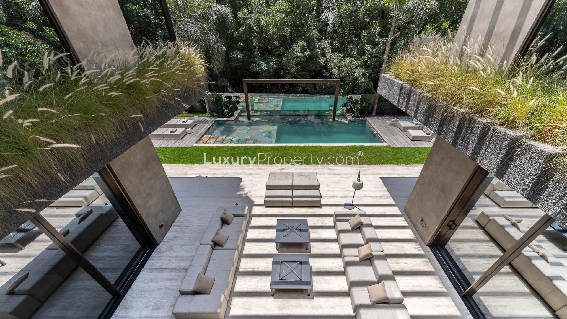 Luxurious Al Barari villa with pool and modern outdoor seating in lush garden setting