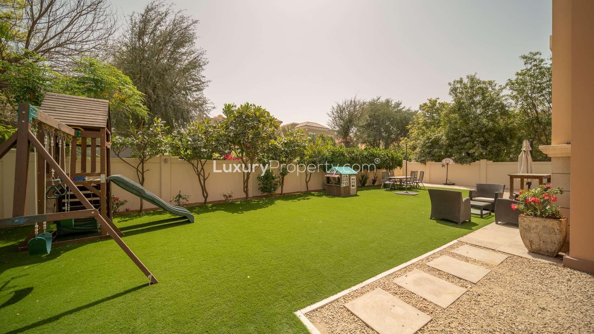 Large garden with seating area and playground in Victory Heights villa, Dubai Sports City