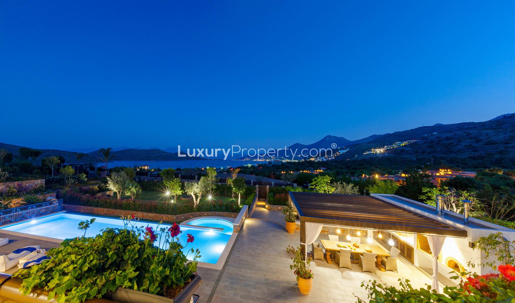 Luxurious 5-bedroom beachfront villa in Crete with illuminated pool and stunning architecture