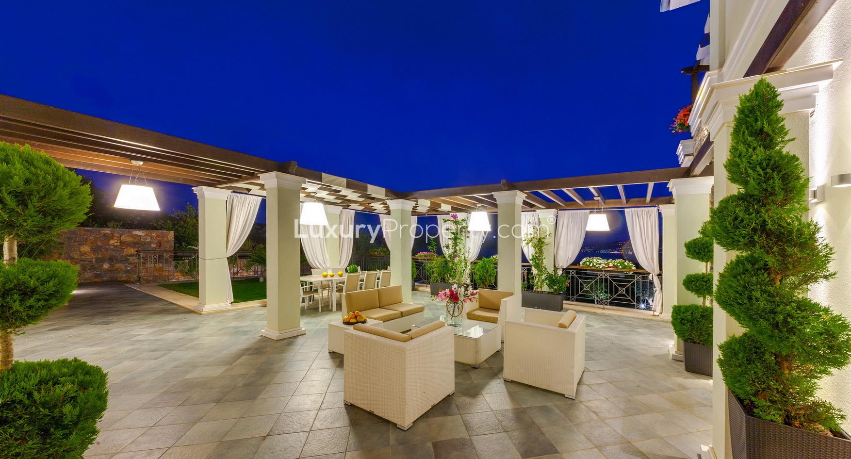 "Stunning Crete villa with pool and mountain views at dusk, Villa Helena beachfront property.",Luxurious outdoor seating area at beachfront villa in Crete, Villa Helena, for sale