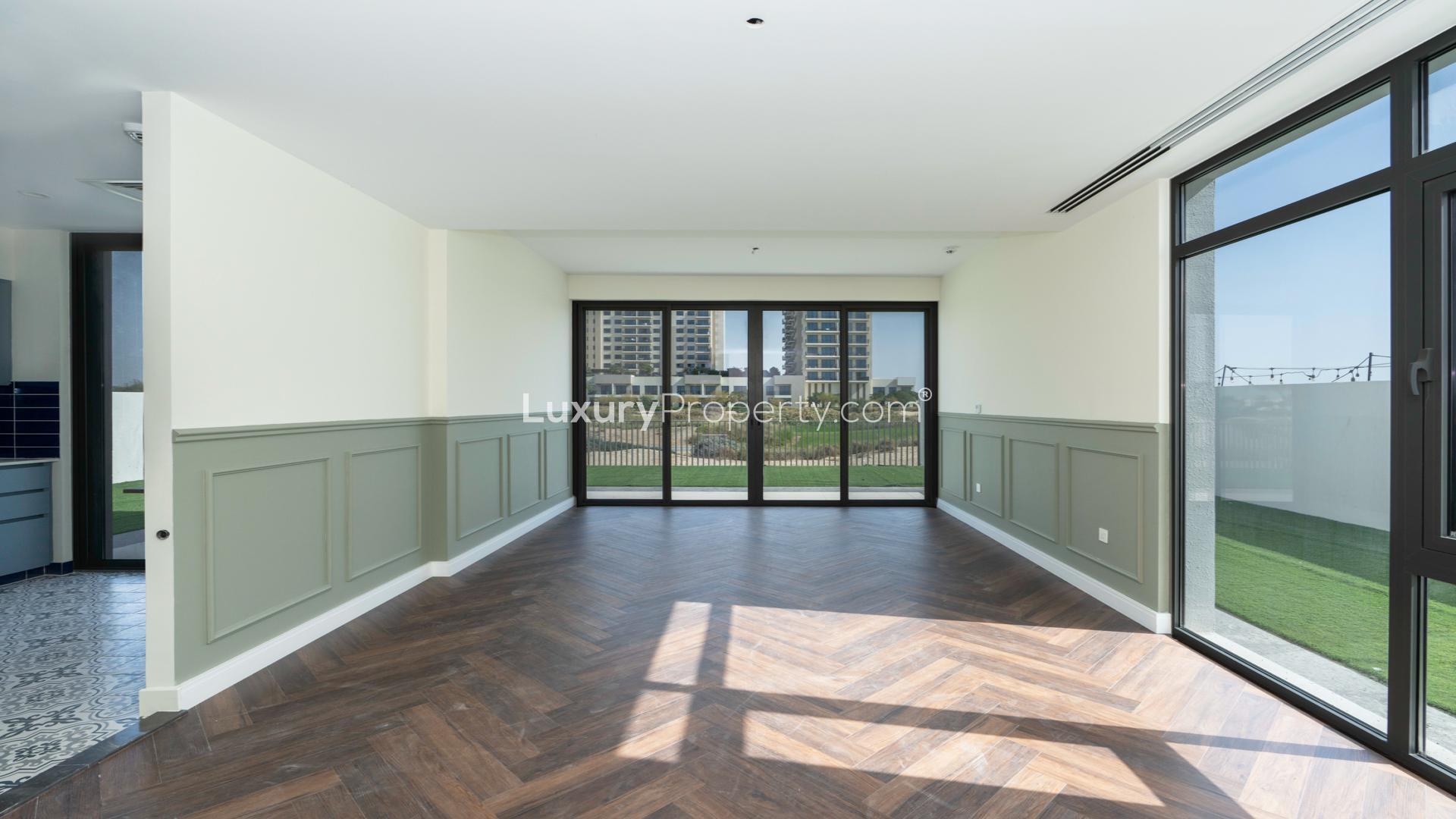 N/A,Bright living room with wooden floors and large windows in Emaar South Golf Links villa