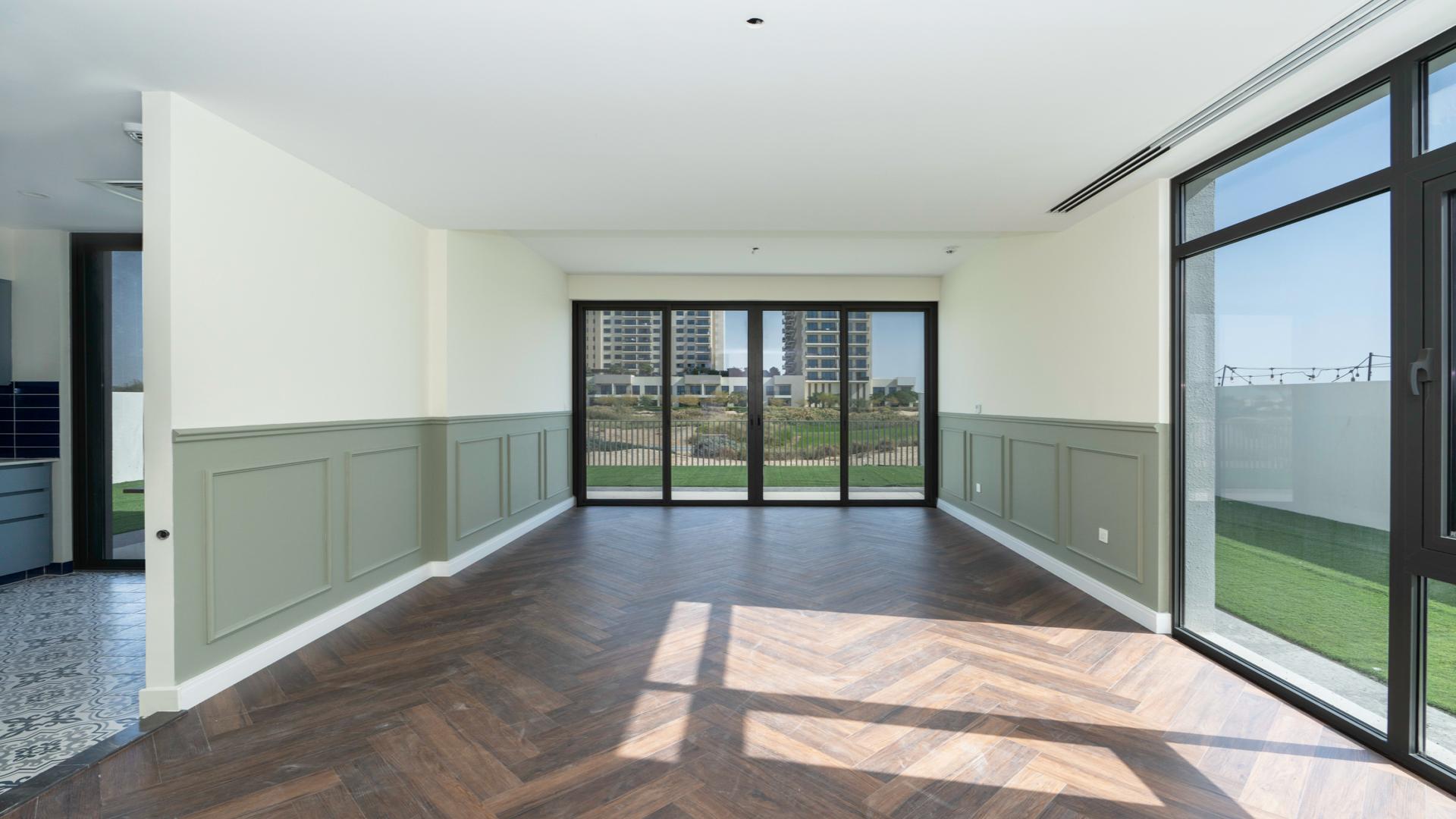 N/A,Bright living room with wooden floors and large windows in Emaar South Golf Links villa