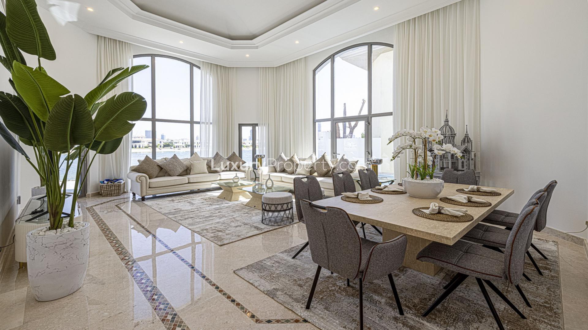Modern furnished living and dining area in Palm Jumeirah villa, featuring large windows and decor