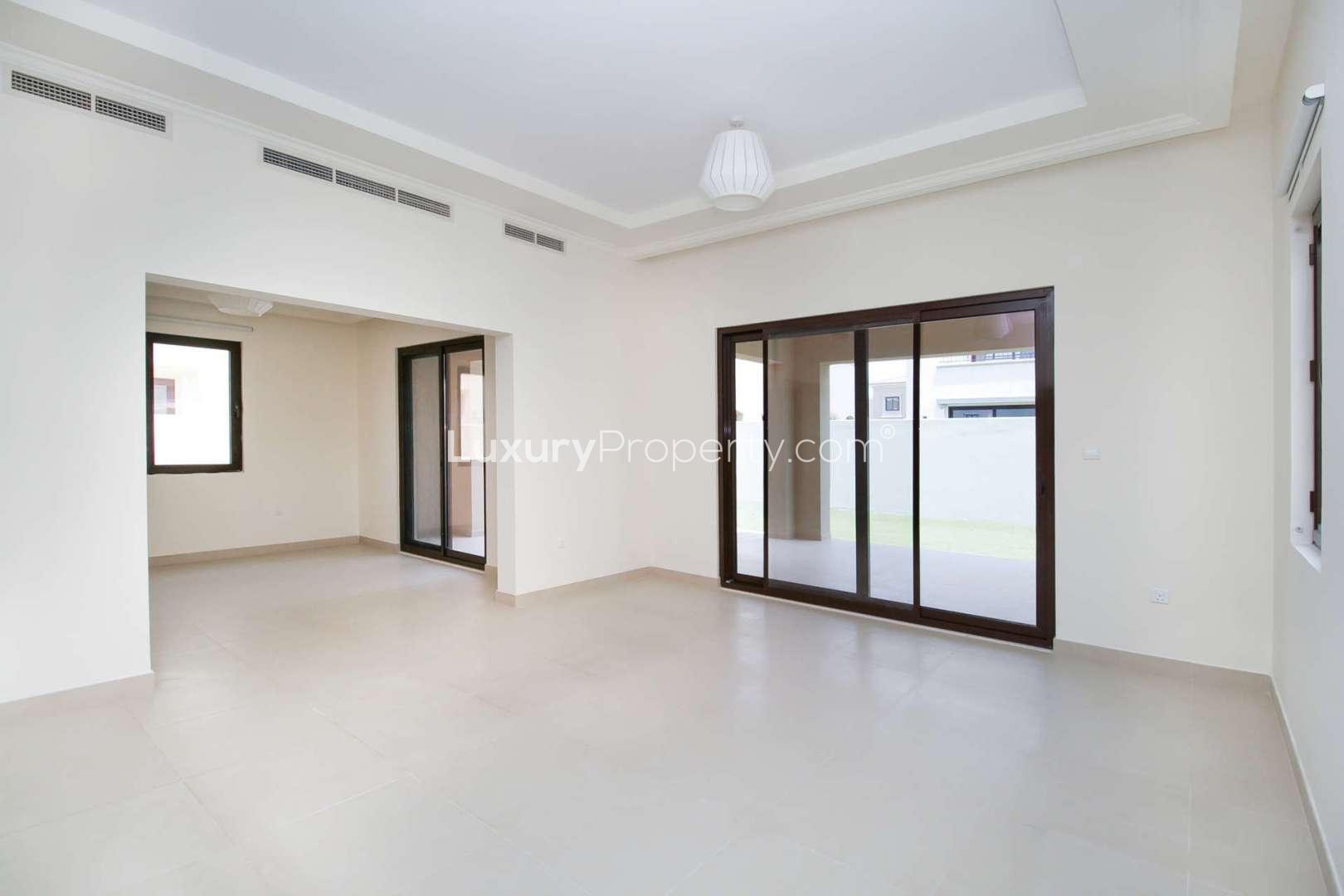 Spacious living area in Arabian Ranches 2 villa for sale, featuring large windows and doors