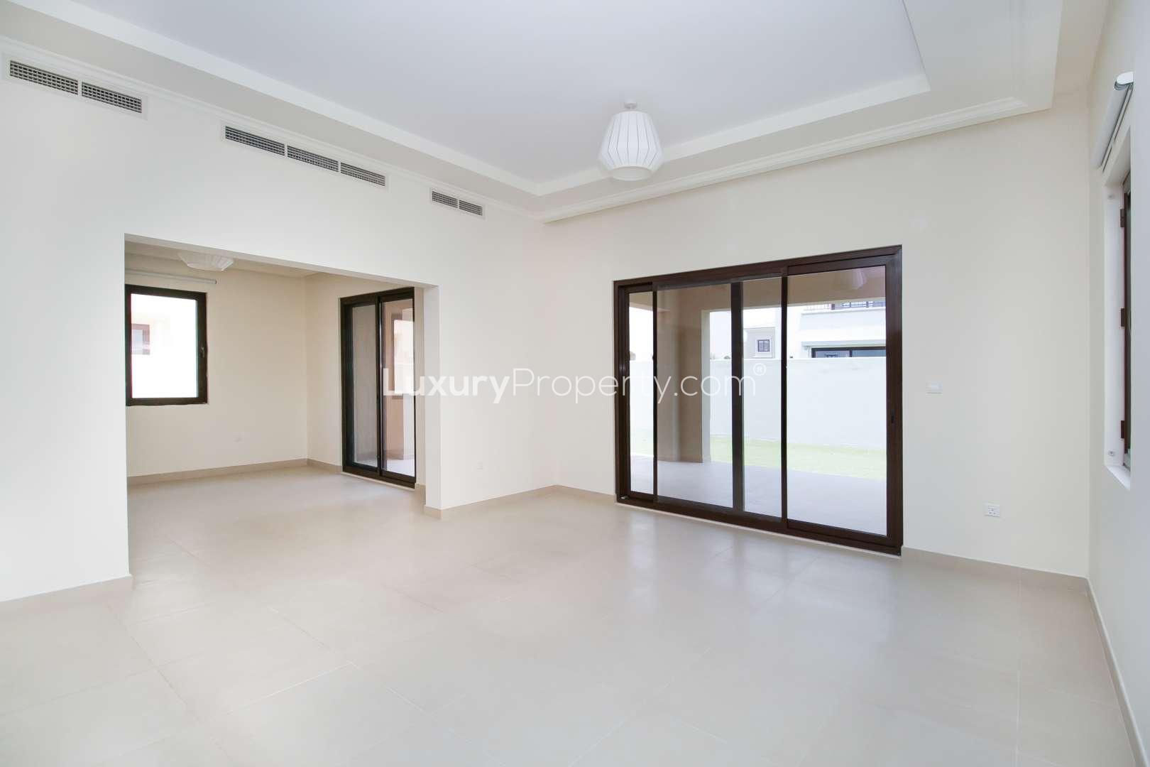 Empty bedroom in Lila, Arabian Ranches 2 villa, featuring a large window and neutral tones