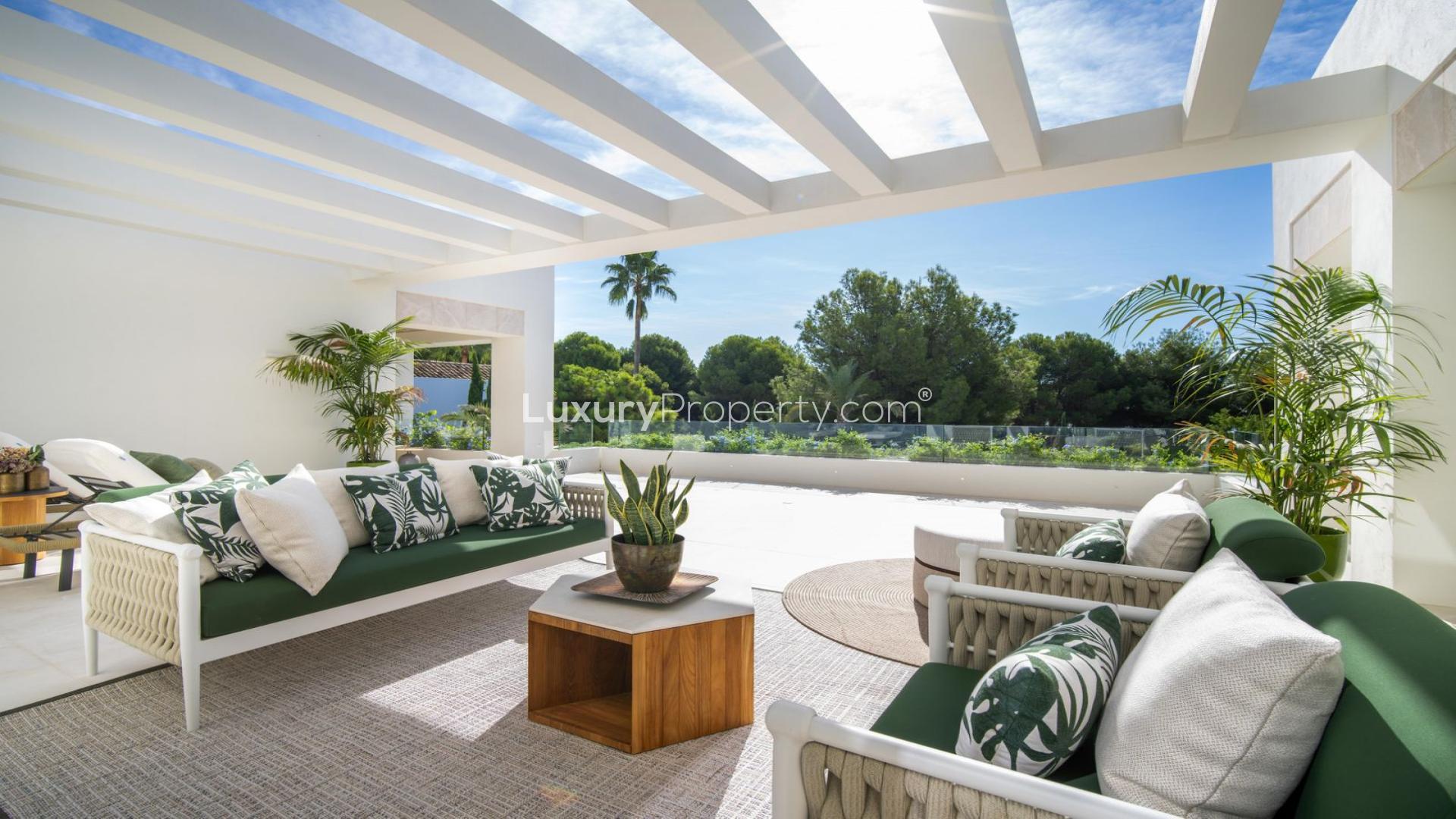 "Elegant outdoor seating area in Marbella villa, surrounded by lush greenery, The Golden Mile.",Luxurious outdoor terrace of 5-bedroom villa in Marbella's gated community, The Golden Mile
