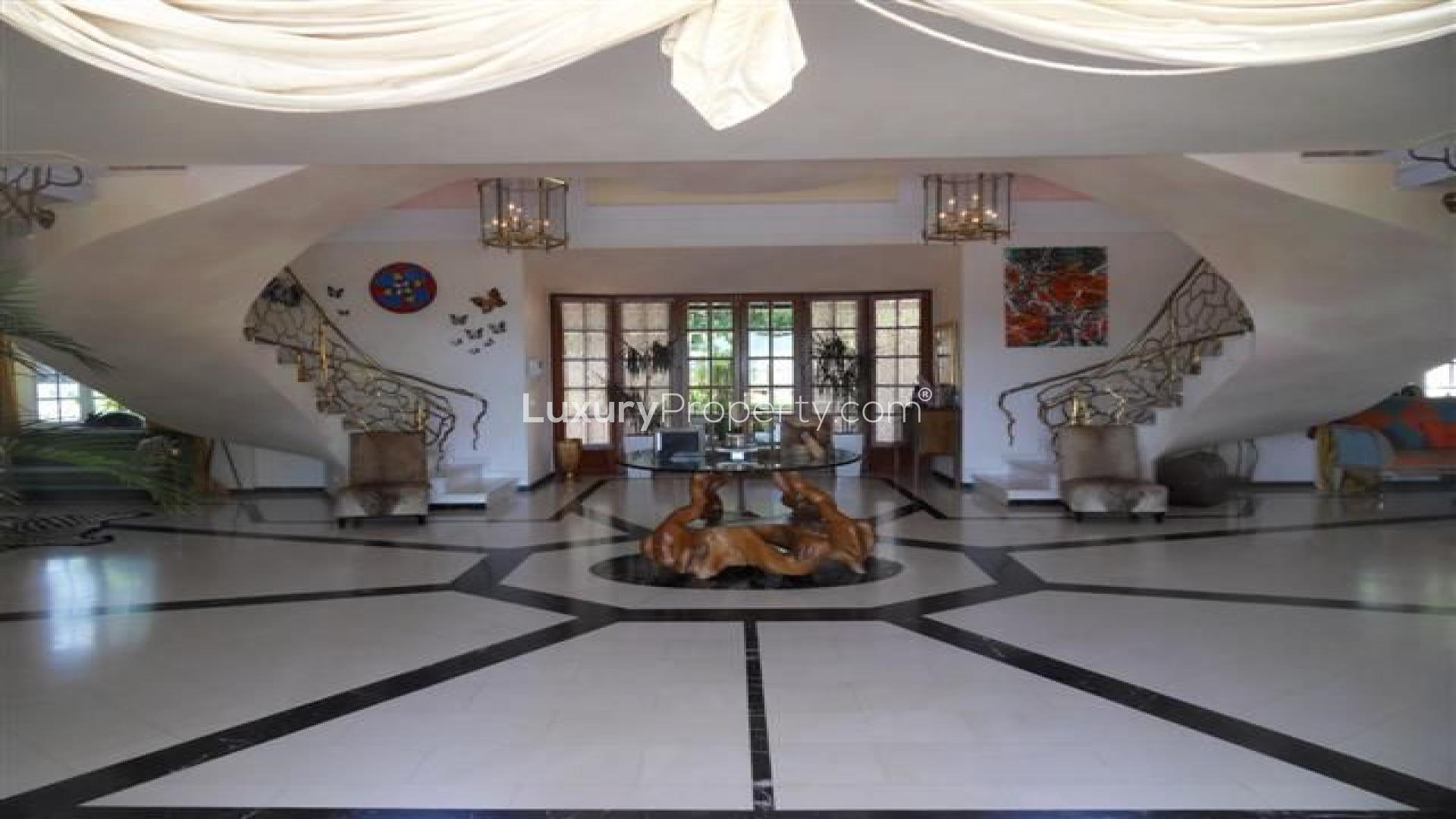 Elegant entrance of 8-bedroom villa in La Quinta, Marbella with grand staircase and chandeliers