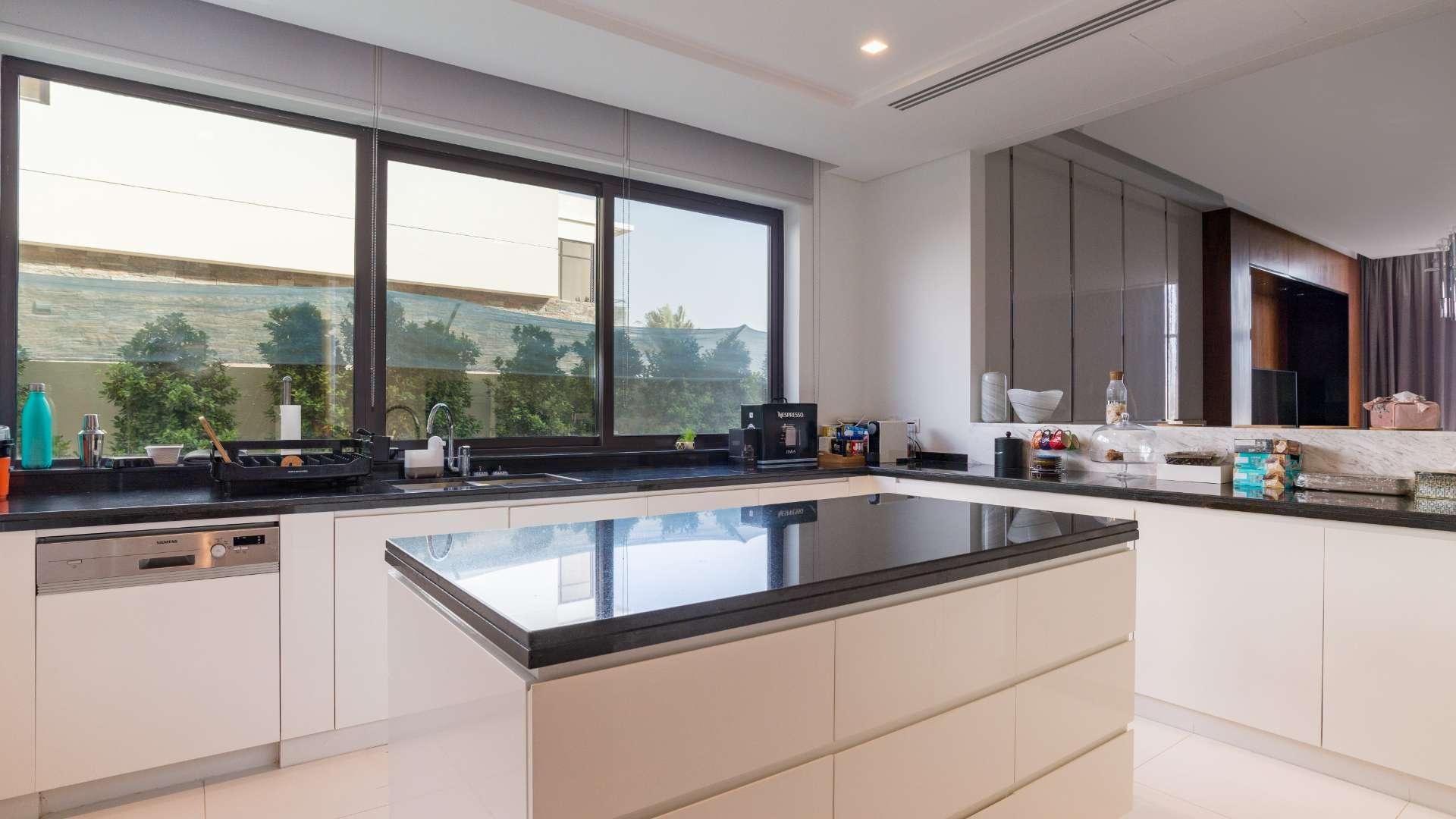 Modern villa exterior with private pool and golf course view in Damac Hills, Silver Springs