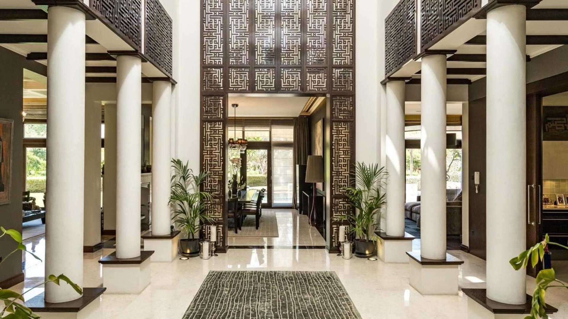 Luxurious Mediterranean villa entrance with elegant columns in Al Barari, Desert Leaf 5