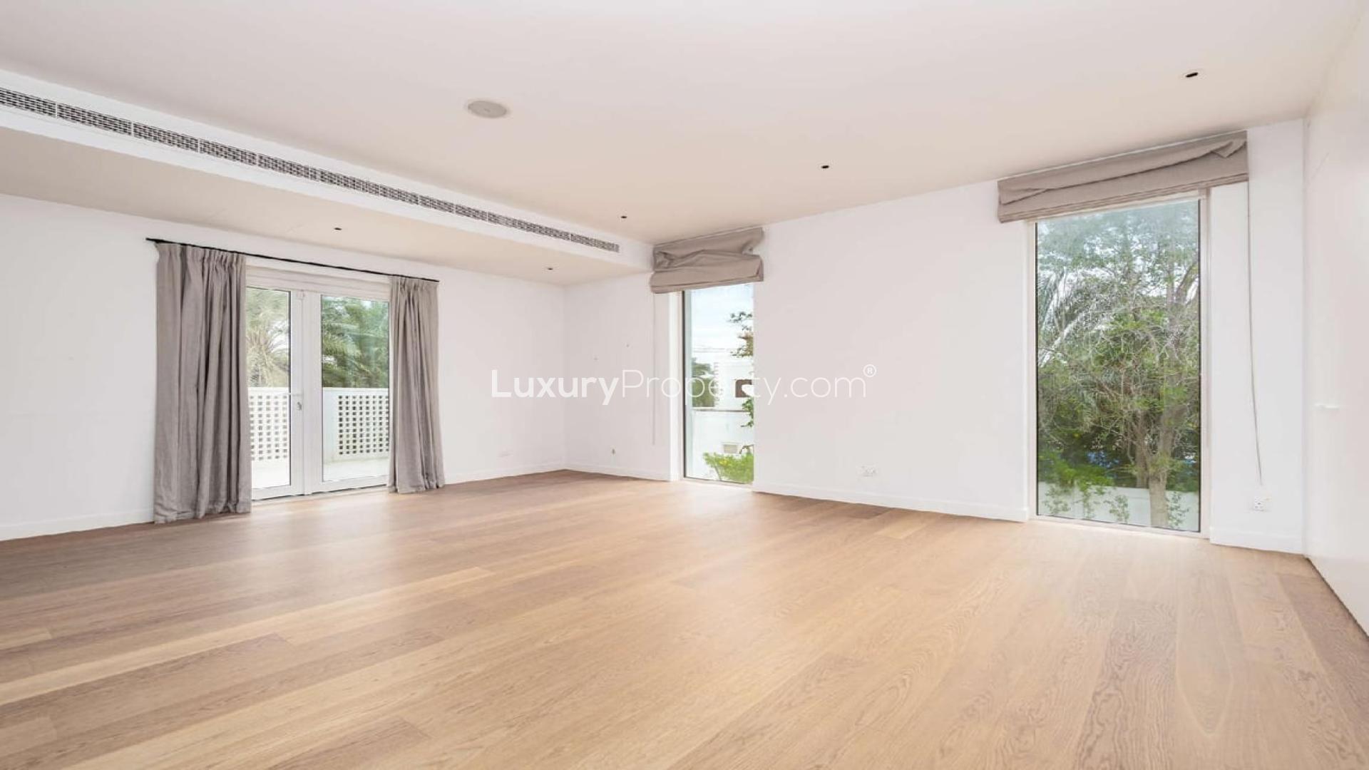 Beautiful villa exterior in Emirates Hills, Dubai with lush greenery and modern architecture