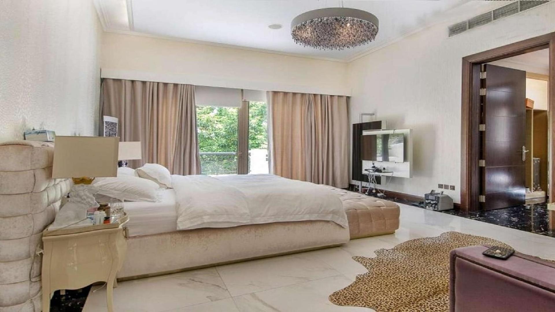 Luxurious hallway in 6-bedroom Dahlia Villa, Al Barari, featuring elegant decor and artwork