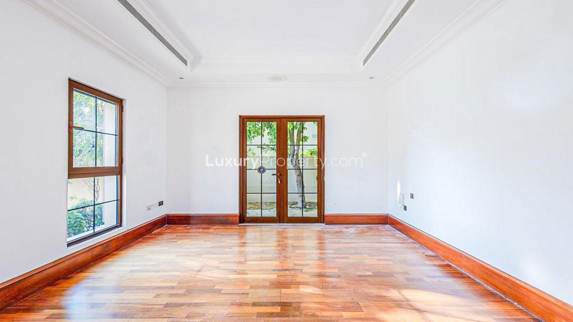 Empty room with tiled floor and large windows in Jumeirah Golf Estates villa for rent