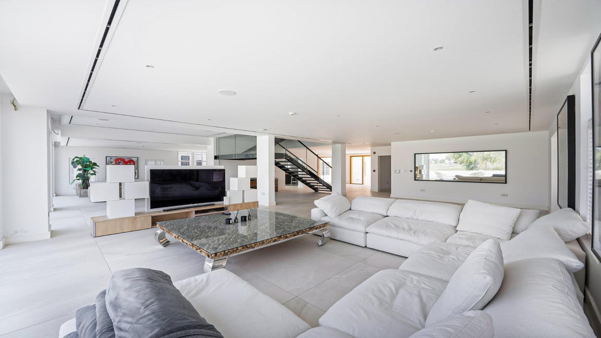 Modern open-plan living room in luxury villa, Jumeirah Golf Estates, with scenic golf course view