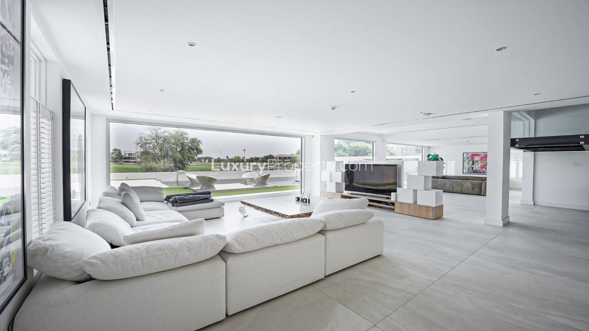 Open-plan living room in high-end villa, Jumeirah Golf Estates, with garden view