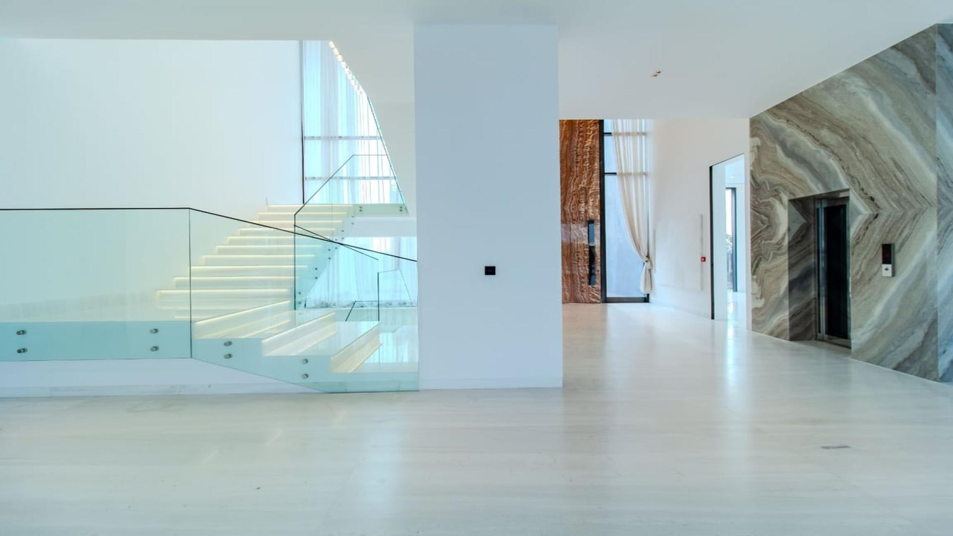 Modern staircase and chandelier in 6-bedroom villa, Emerald Hills, Dubai Hills Estate