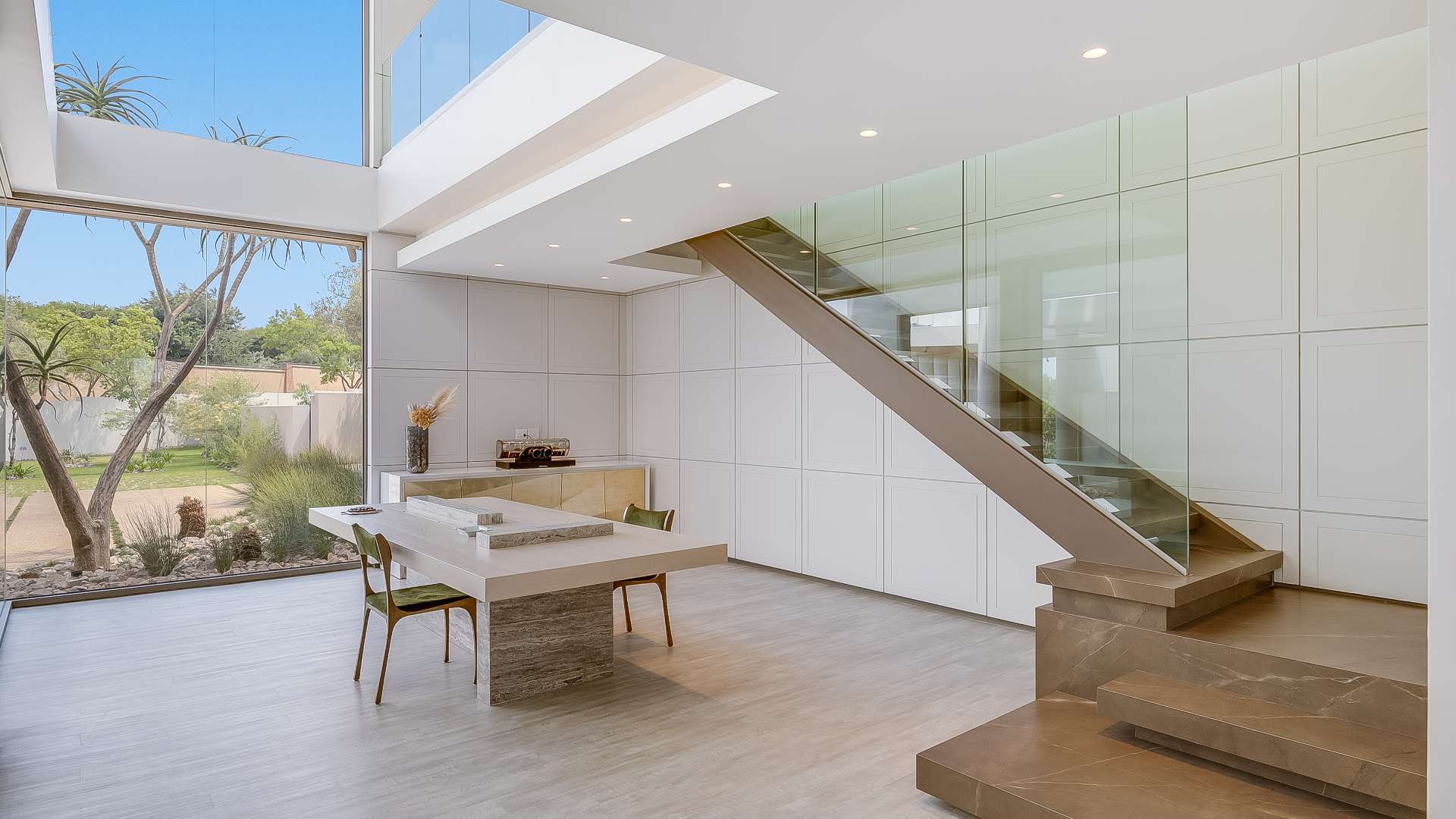 Luxury villa interior with modern dining area, large windows, and garden view in Waterfall City