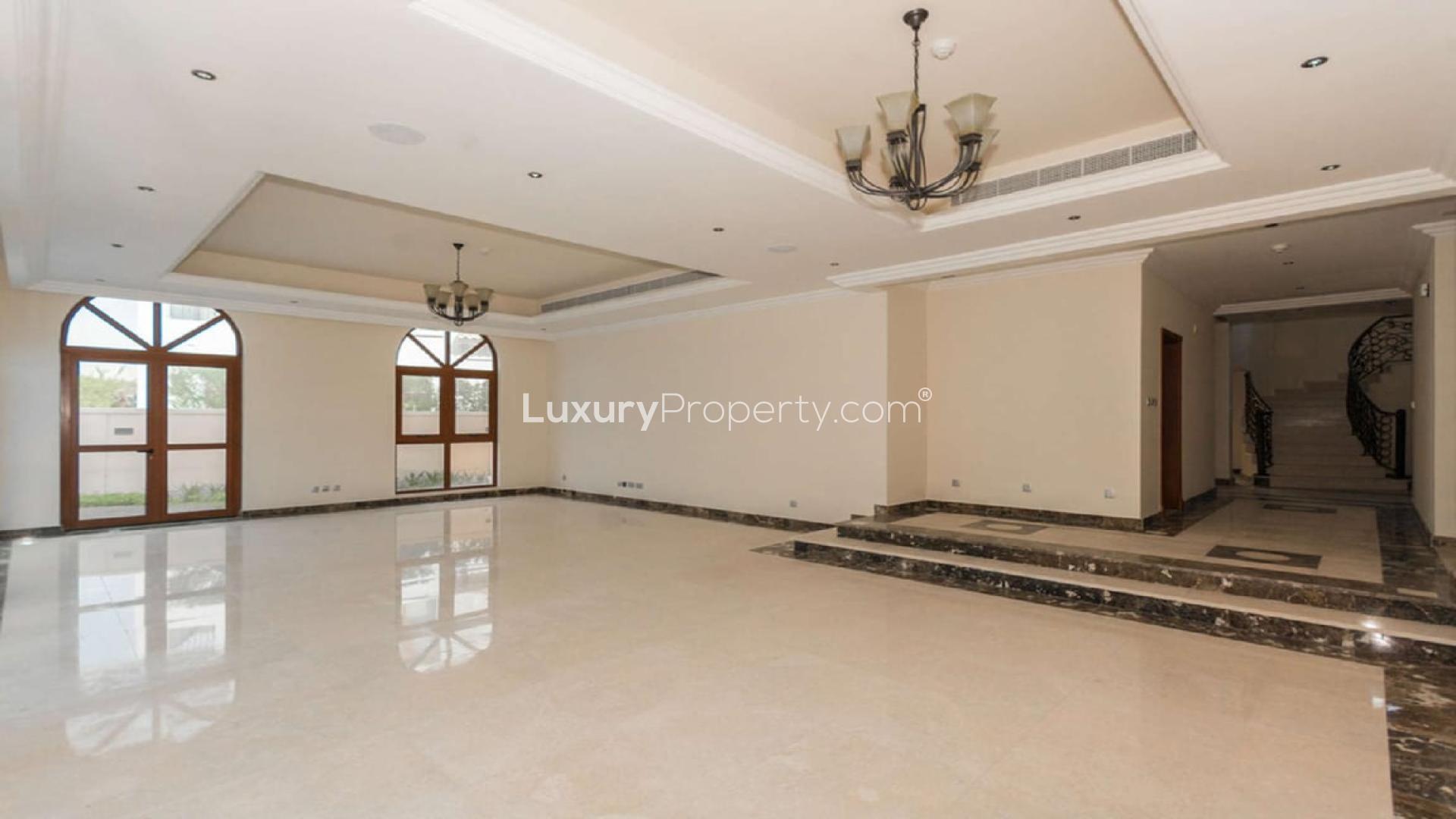 Spacious living room with large windows in Jumeirah Golf Estates villa for rent
