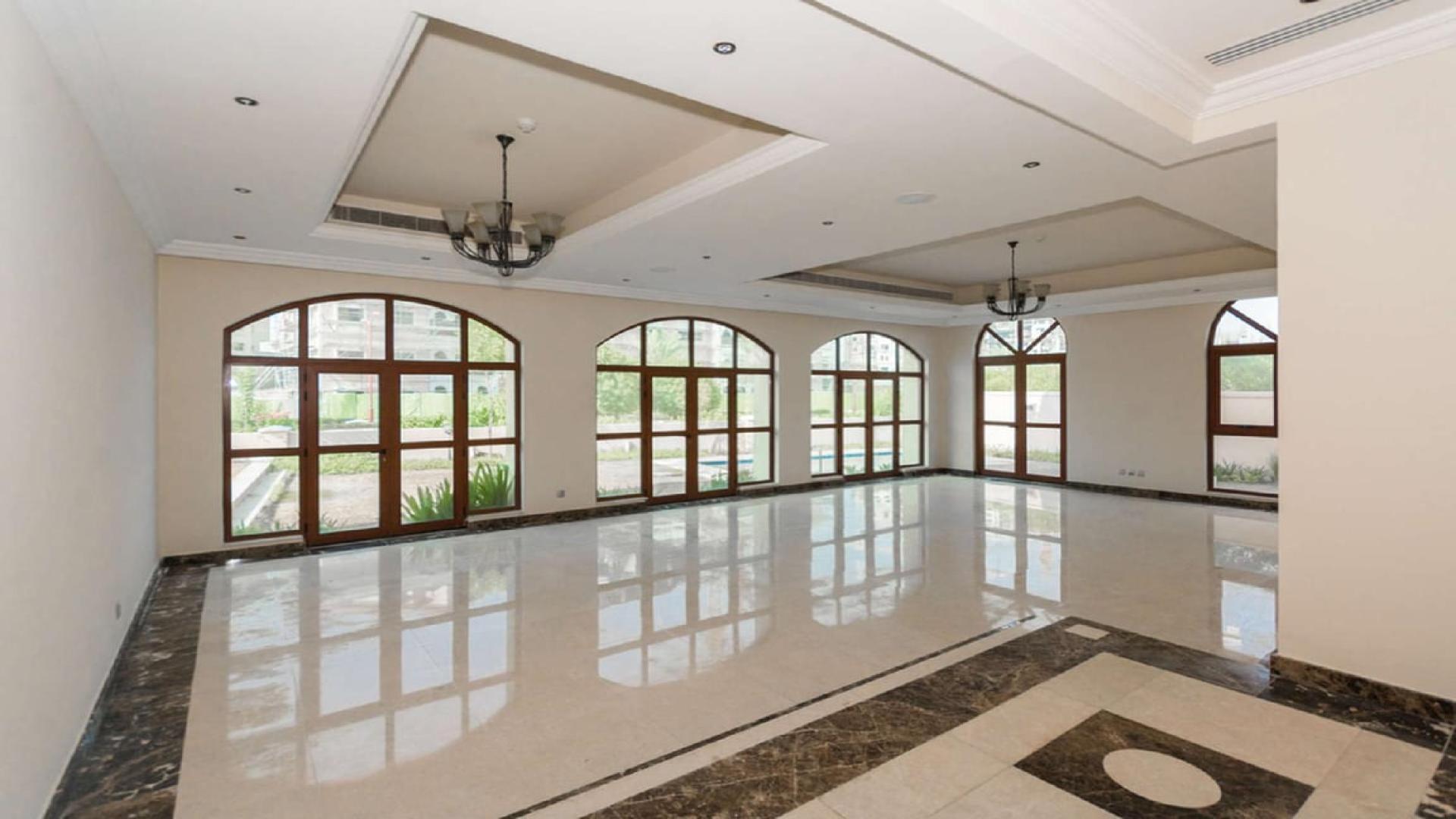Spacious living room with large windows in Jumeirah Golf Estates villa for sale