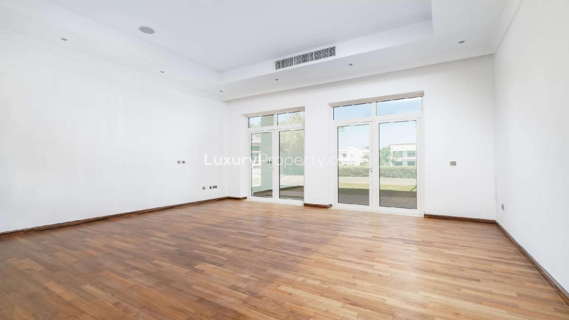 Luxurious living room in 6-bedroom villa, Emirates Hills, featuring spacious seating and garden view