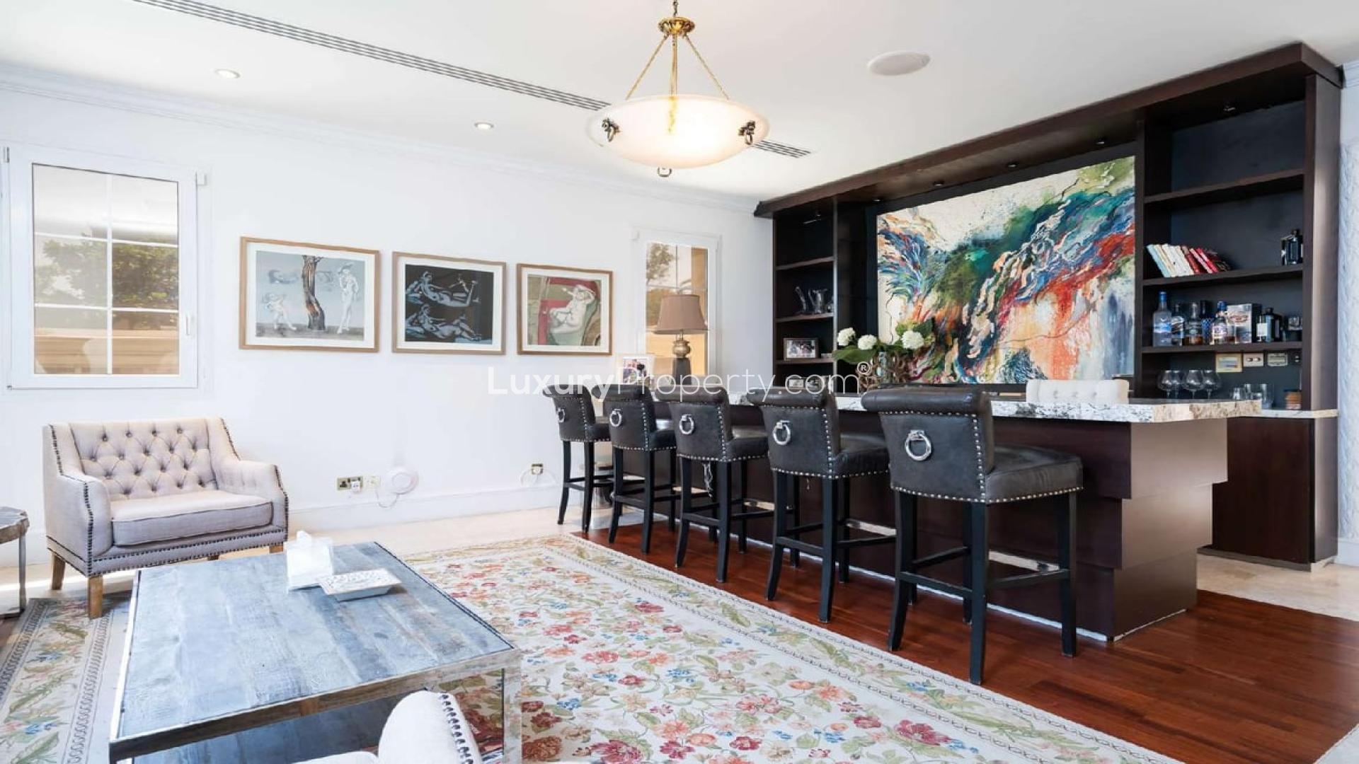 Luxury 6-bedroom villa exterior in Emirates Hills, Dubai with lush greenery and palm trees