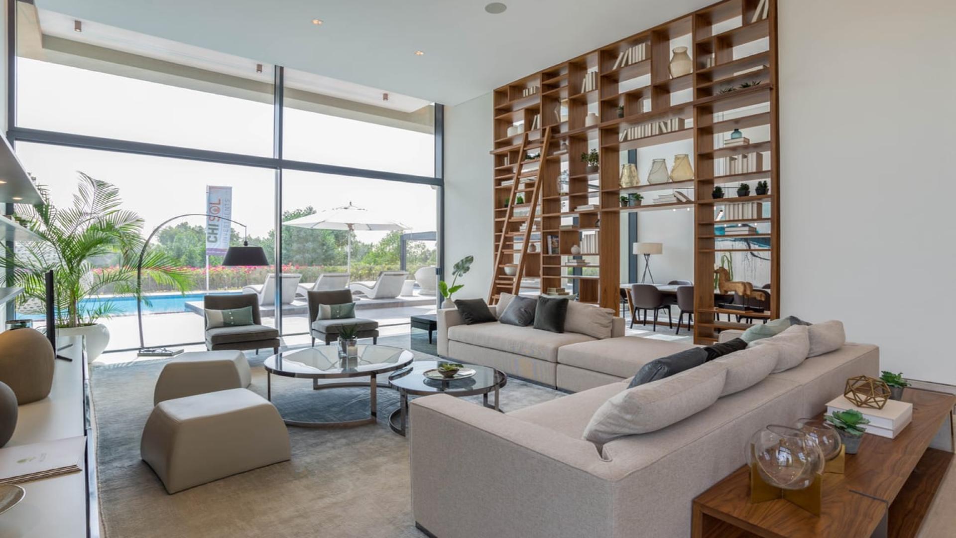 Luxurious villa living room with modern decor, large windows, and pool view at Jumeirah Golf Estates