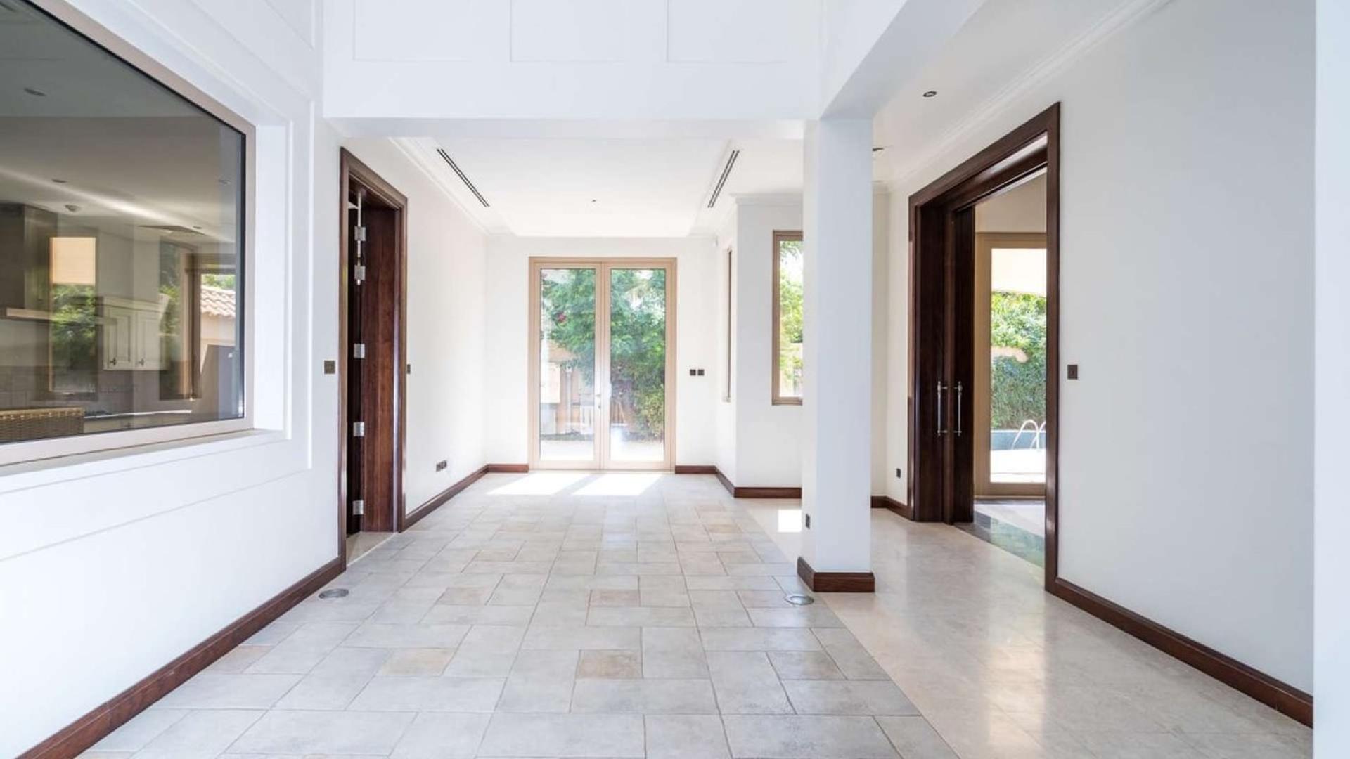 Spacious interior of Desert Leaf Villa in Ajman Uptown with large windows and garden view