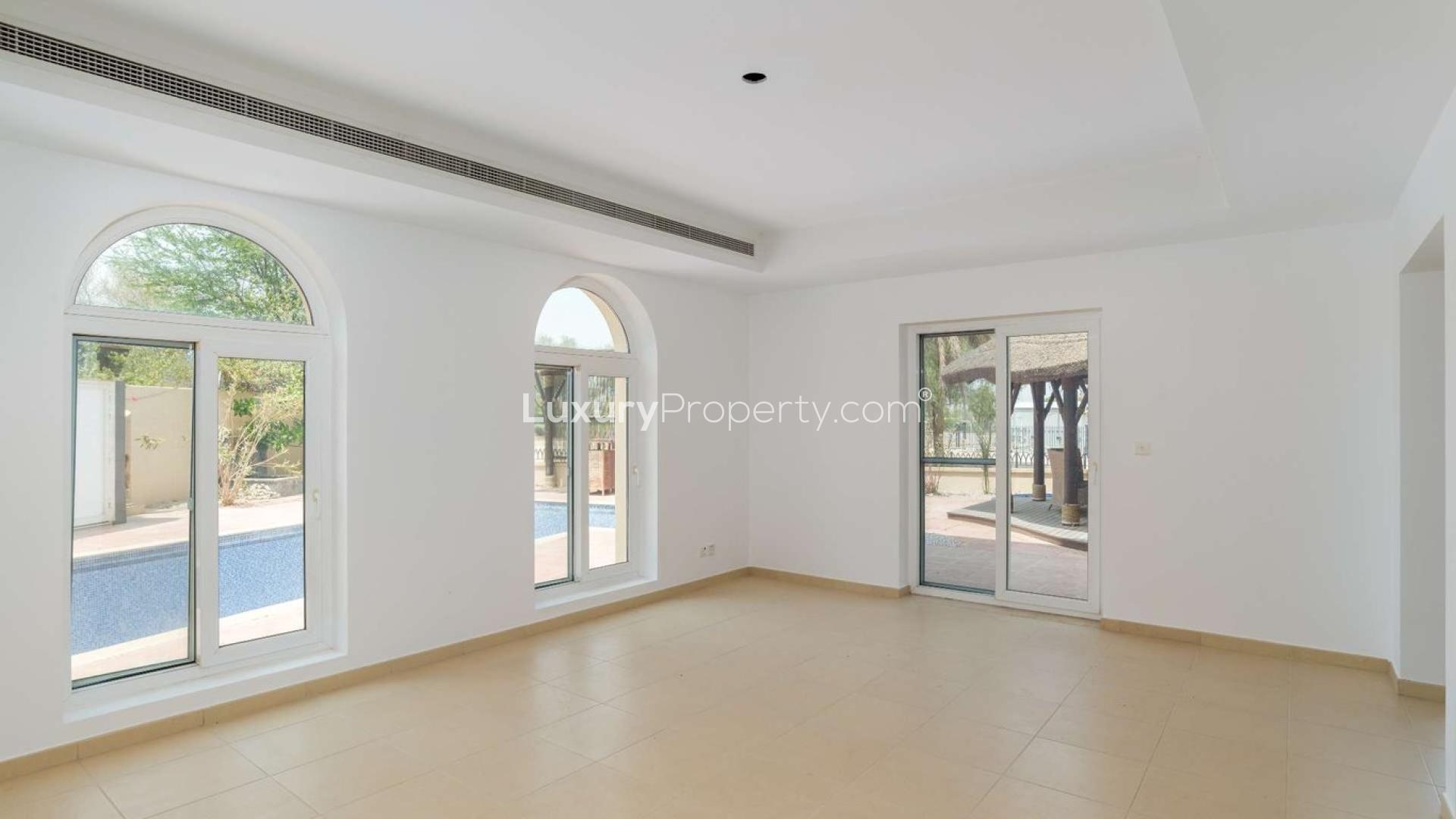 Spacious living area in Al Mahra villa, Arabian Ranches with elegant arches and large windows