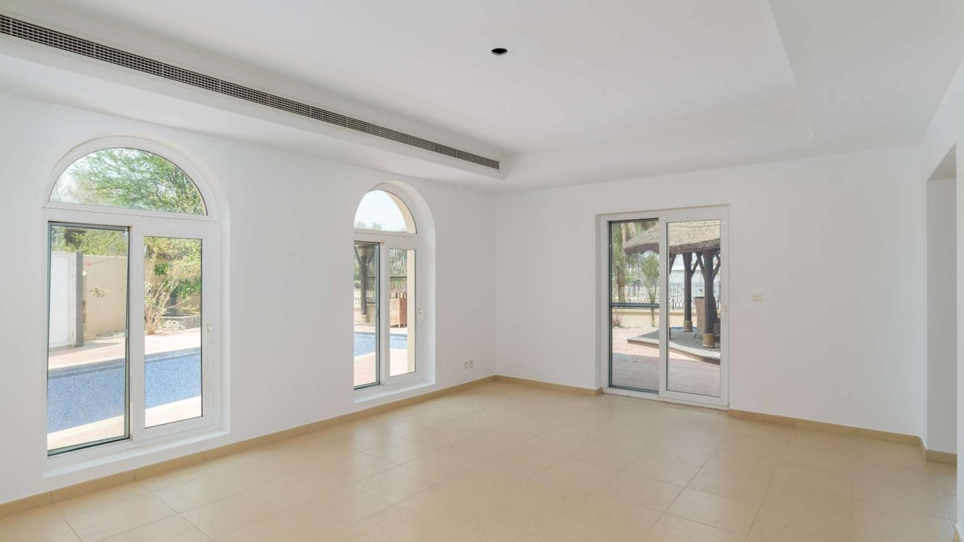 Spacious living area in Al Mahra villa, Arabian Ranches with elegant arches and large windows