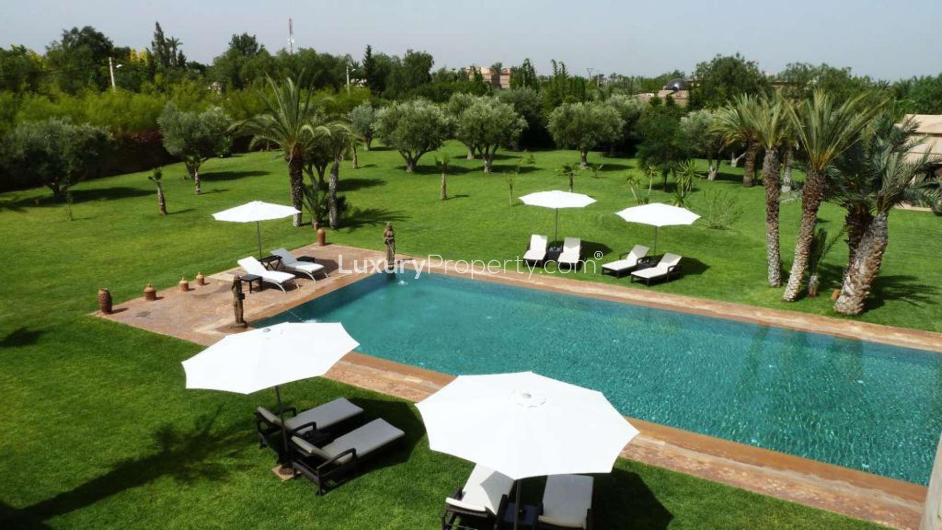 Opulent villa pool with palm trees and inflatable duck in Palmeraie, Marrakech