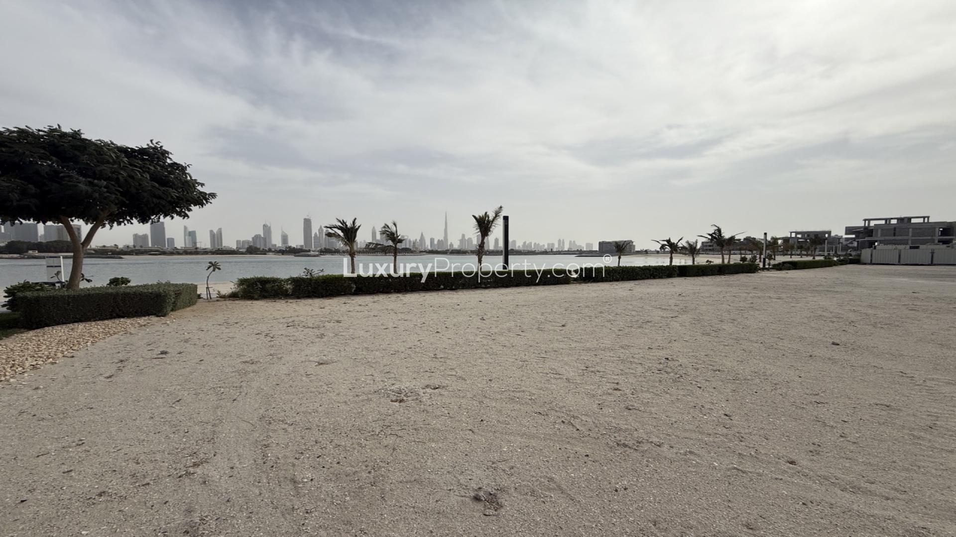 Alt text: "Pearl Jumeirah land for sale, private beach access, Dubai skyline views, lush greenery."