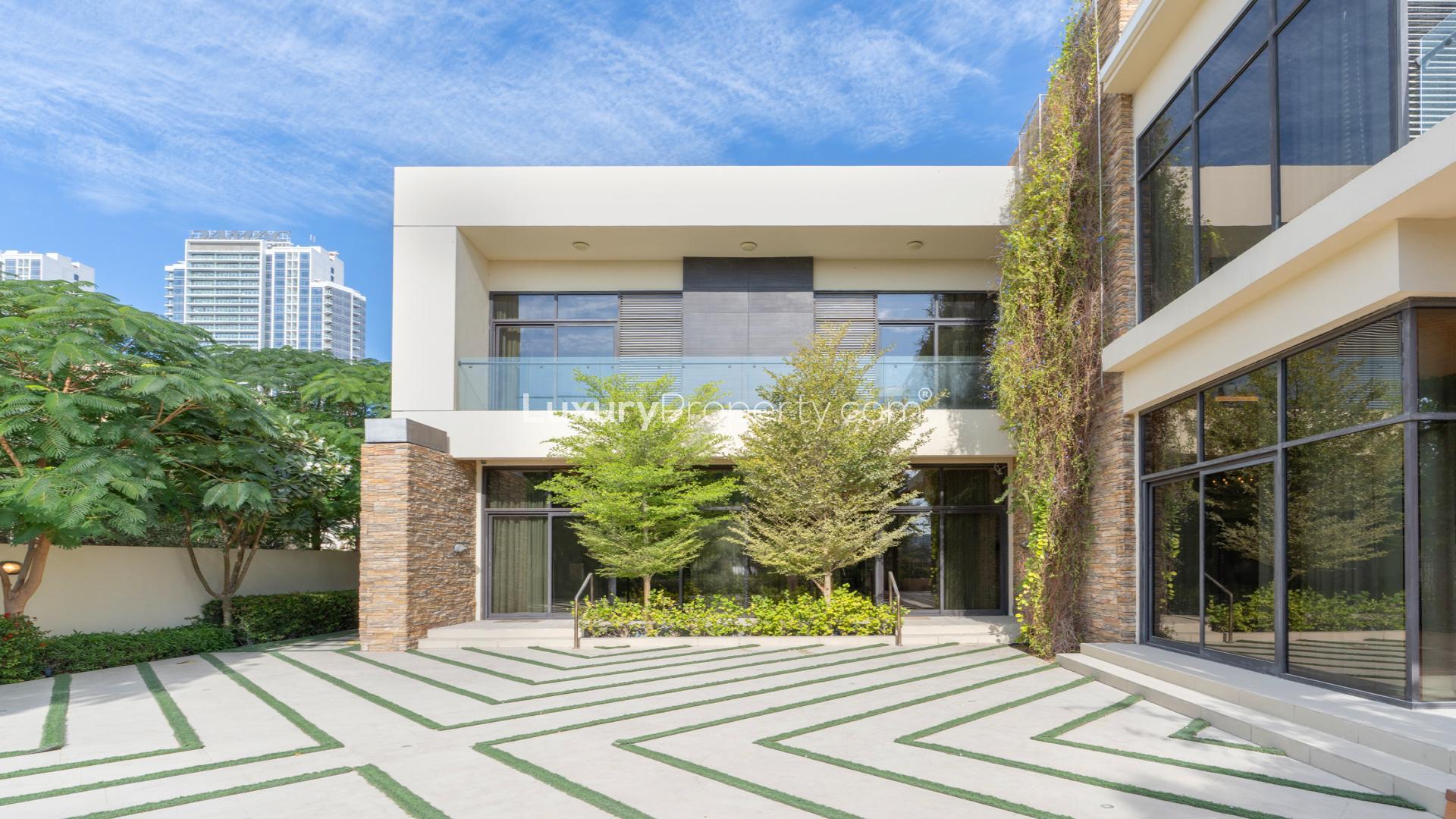 Luxury villa exterior with landscaped courtyard at night, Damac Hills, Brookfield 1