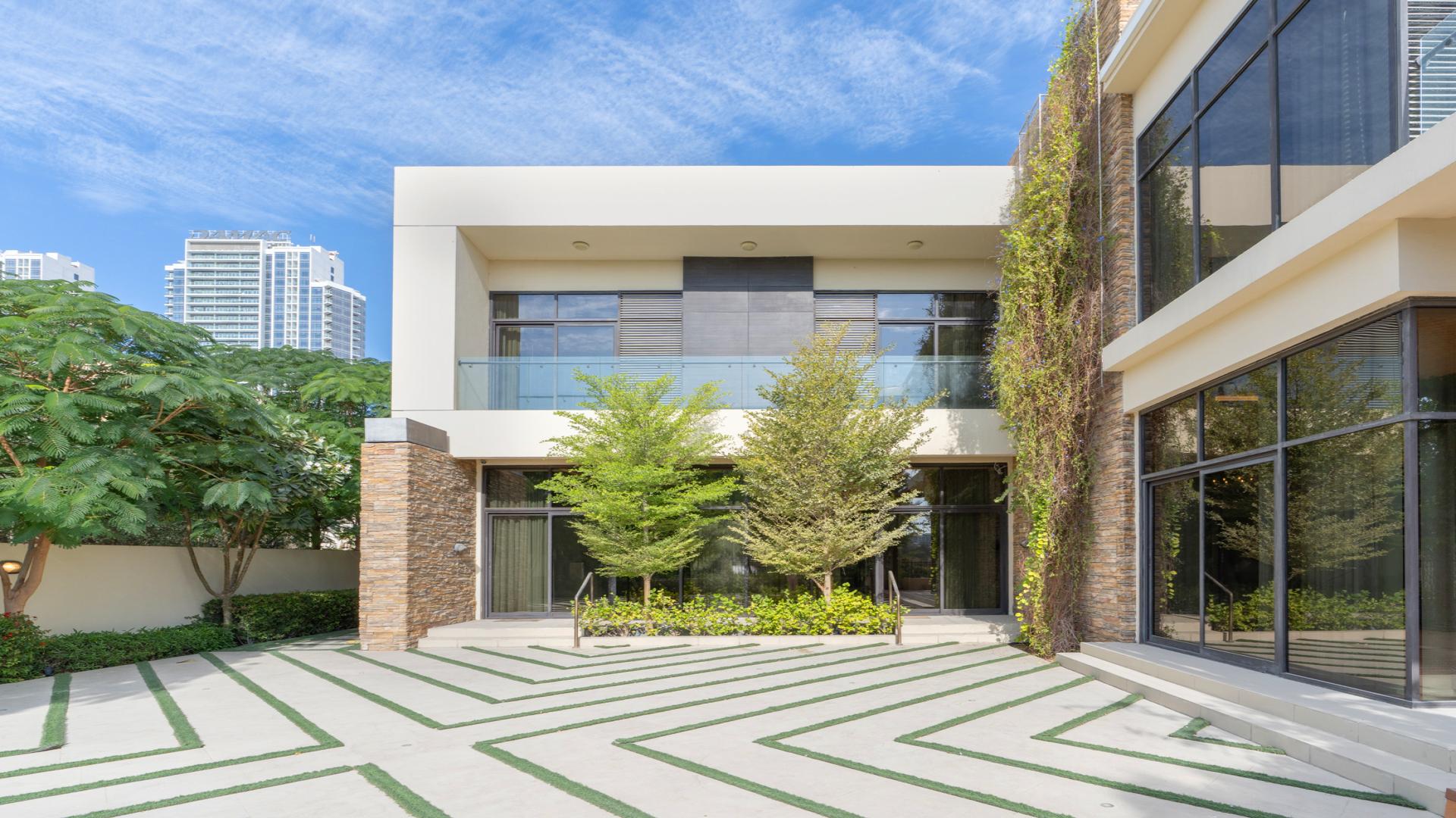 Luxury villa exterior with landscaped courtyard at night, Damac Hills, Brookfield 1
