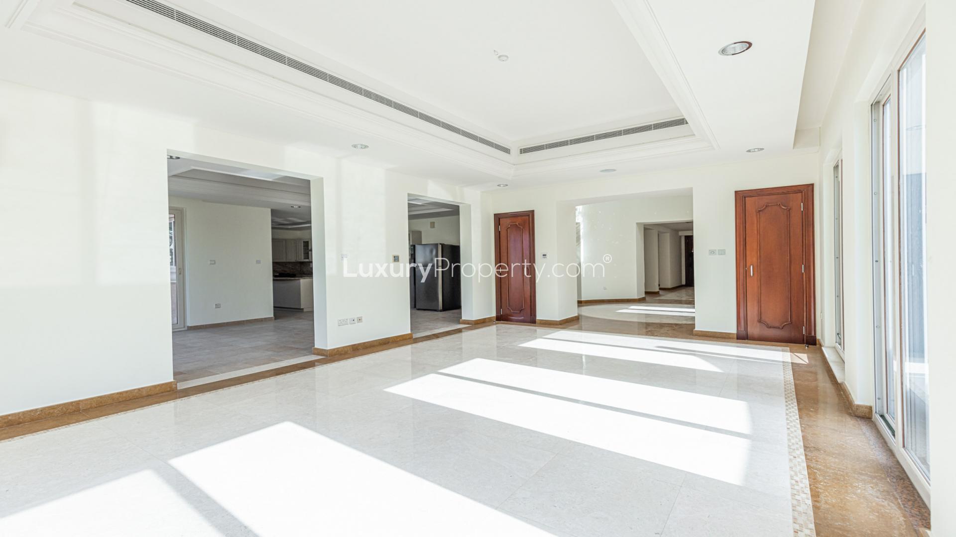 Spacious living area in Victory Heights villa, Dubai Sports City, with large windows and marble floors