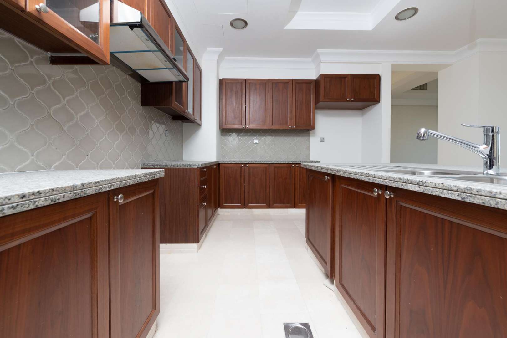 "Scenic view from six-bedroom villa in Aseel, Arabian Ranches, showcasing green landscape.",Luxurious kitchen with wooden cabinets in six-bedroom Aseel villa, Arabian Ranches for rent