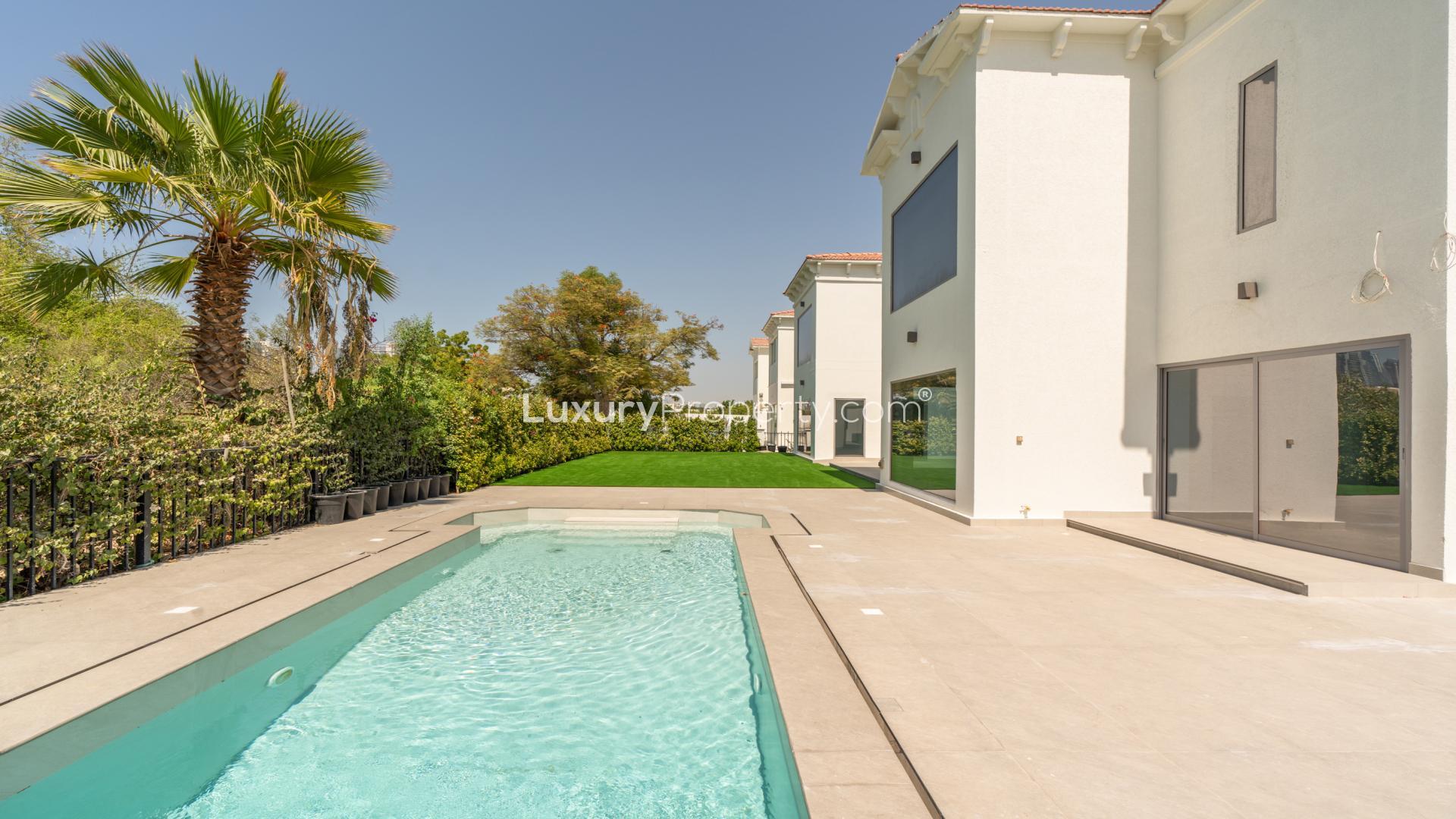 "Elegant 6-bed villa exterior with lush lawn in European Clusters, Jumeirah Islands.",Outdoor pool and patio of luxury villa in European Clusters, Jumeirah Islands
